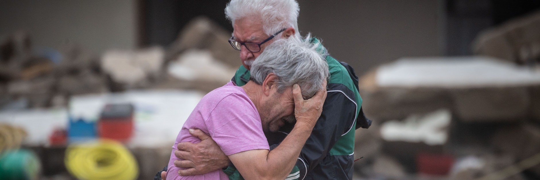 Weinend liegen sich die Brüder Bernd (l.) und Gerd Gasper vor ihrem von der Flut zerstörten Elternhaus in den Armen.