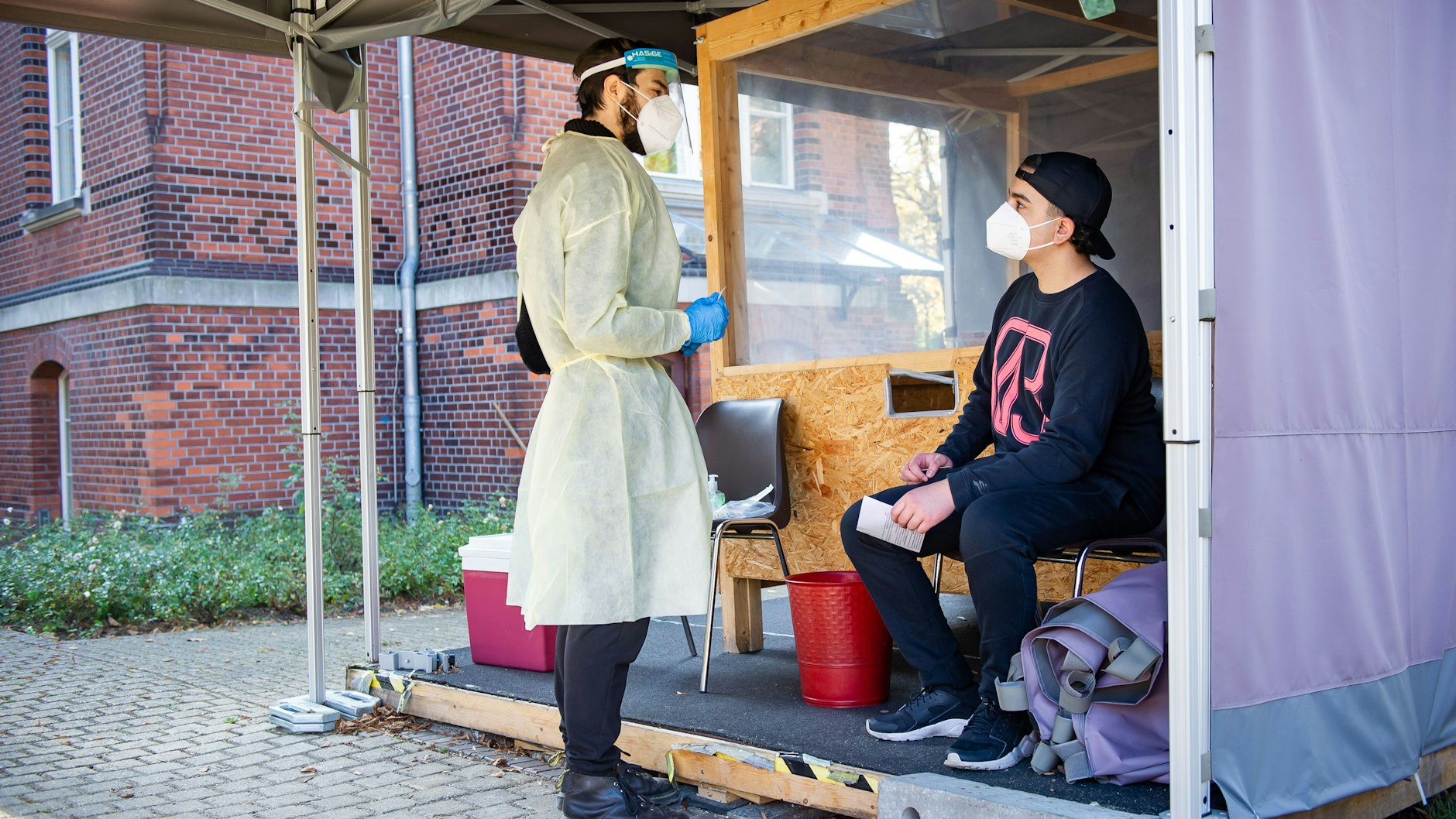 Gratis-Test als Anreiz zur Impf-Beratung? Ali Özdemir (rechts in der Teststelle Blaschkoallee) bleibt skeptisch.