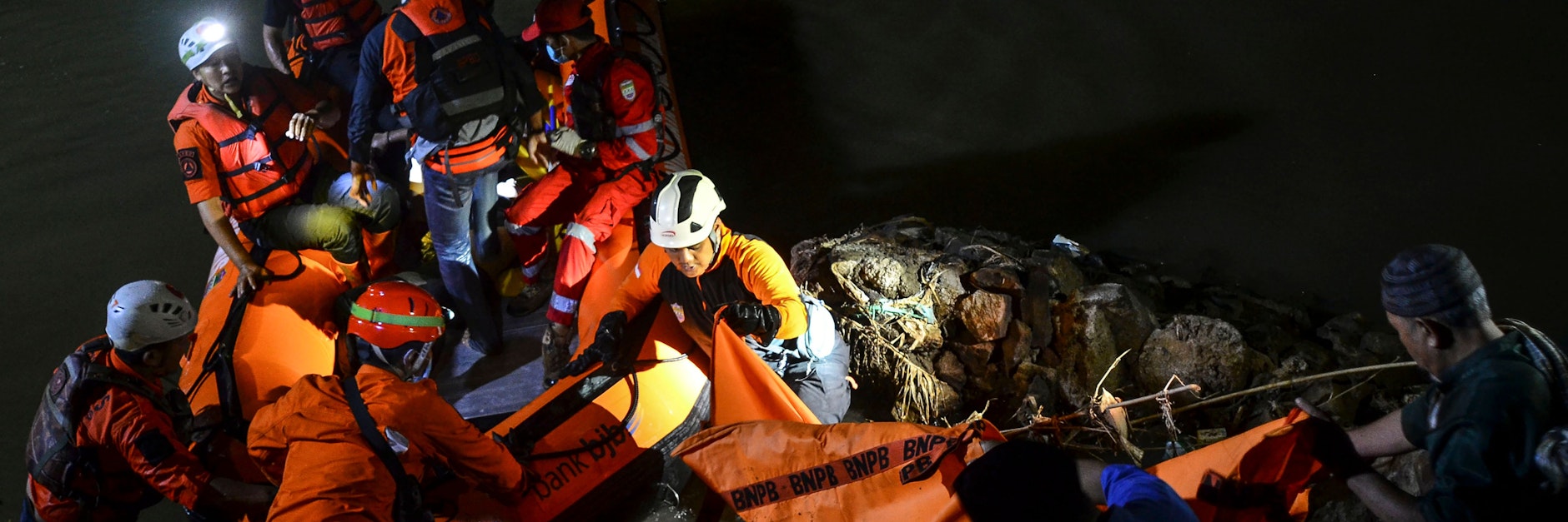 Rettungskräfte in Schlauchbooten suchen nach den von der Strömung mitgerissenen Schulkindern und holen Opfer an Bord.