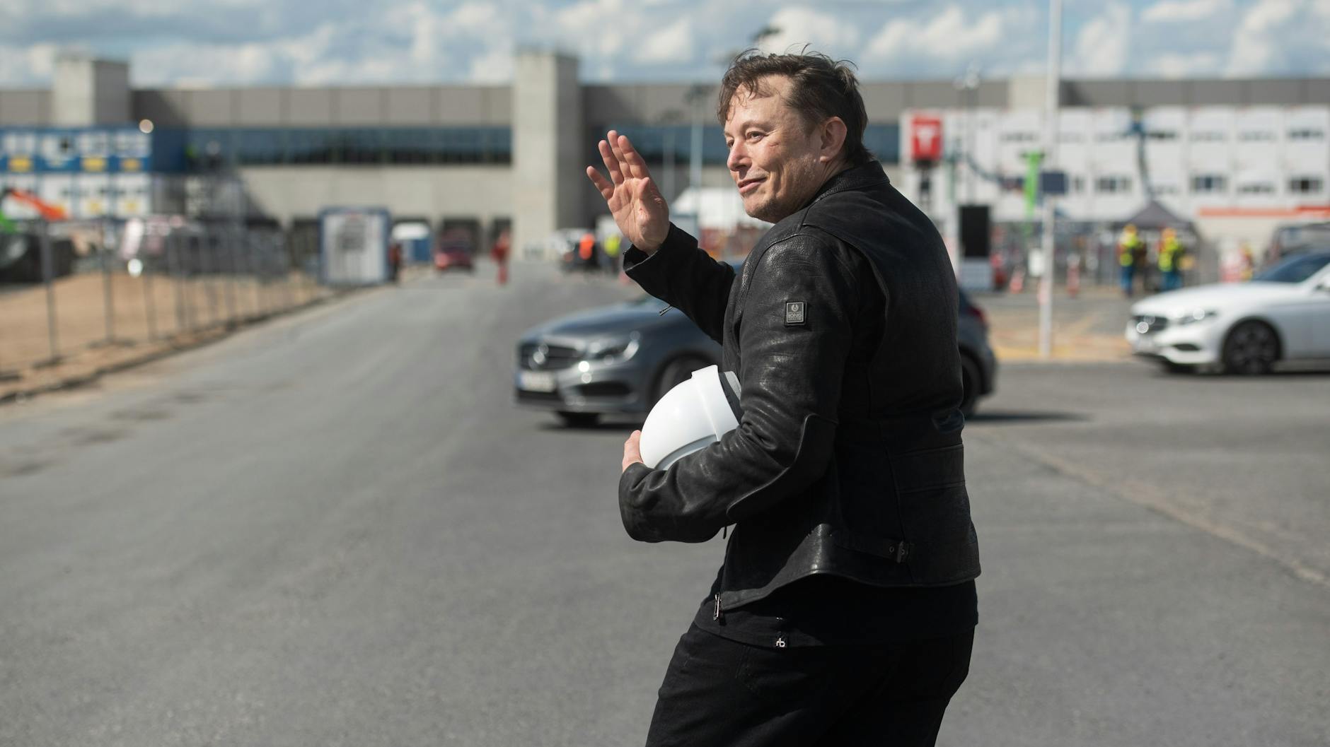Elon Musk, Tesla-Chef, steht auf der Baustelle der Tesla Fabrik und winkt (Archivbild).
