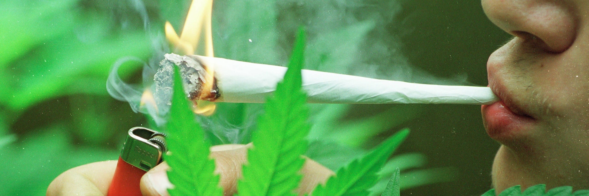 Junger Mann raucht einen Joint