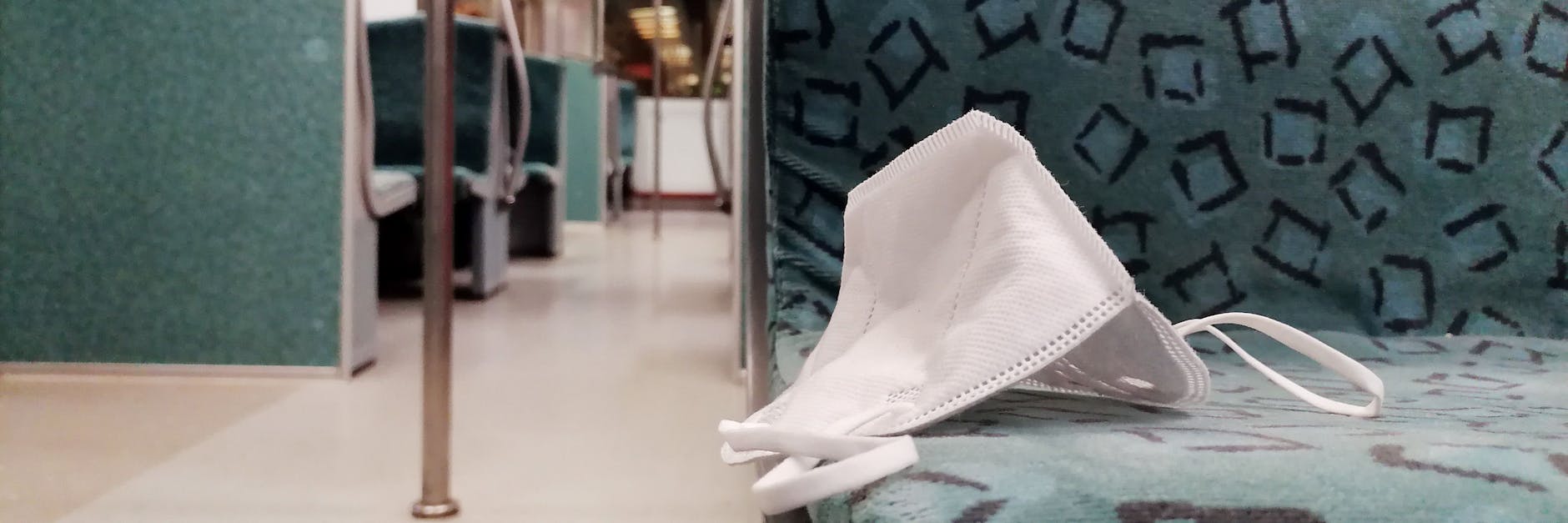 Eine FFP2-Maske liegt in einer S-Bahn in Berlin.