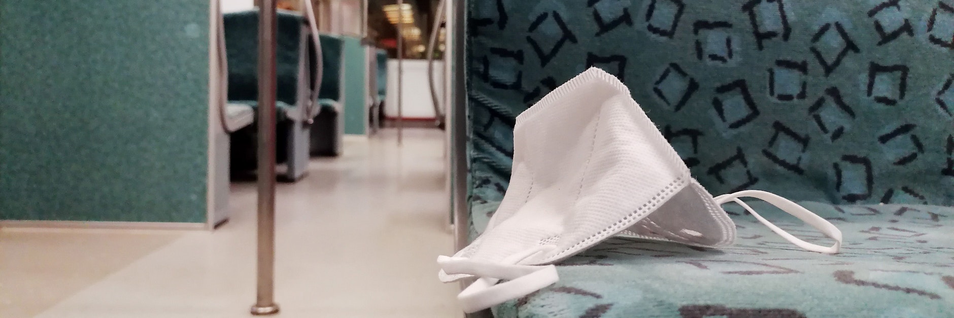 Eine FFP2-Maske liegt in einer S-Bahn in Berlin.
