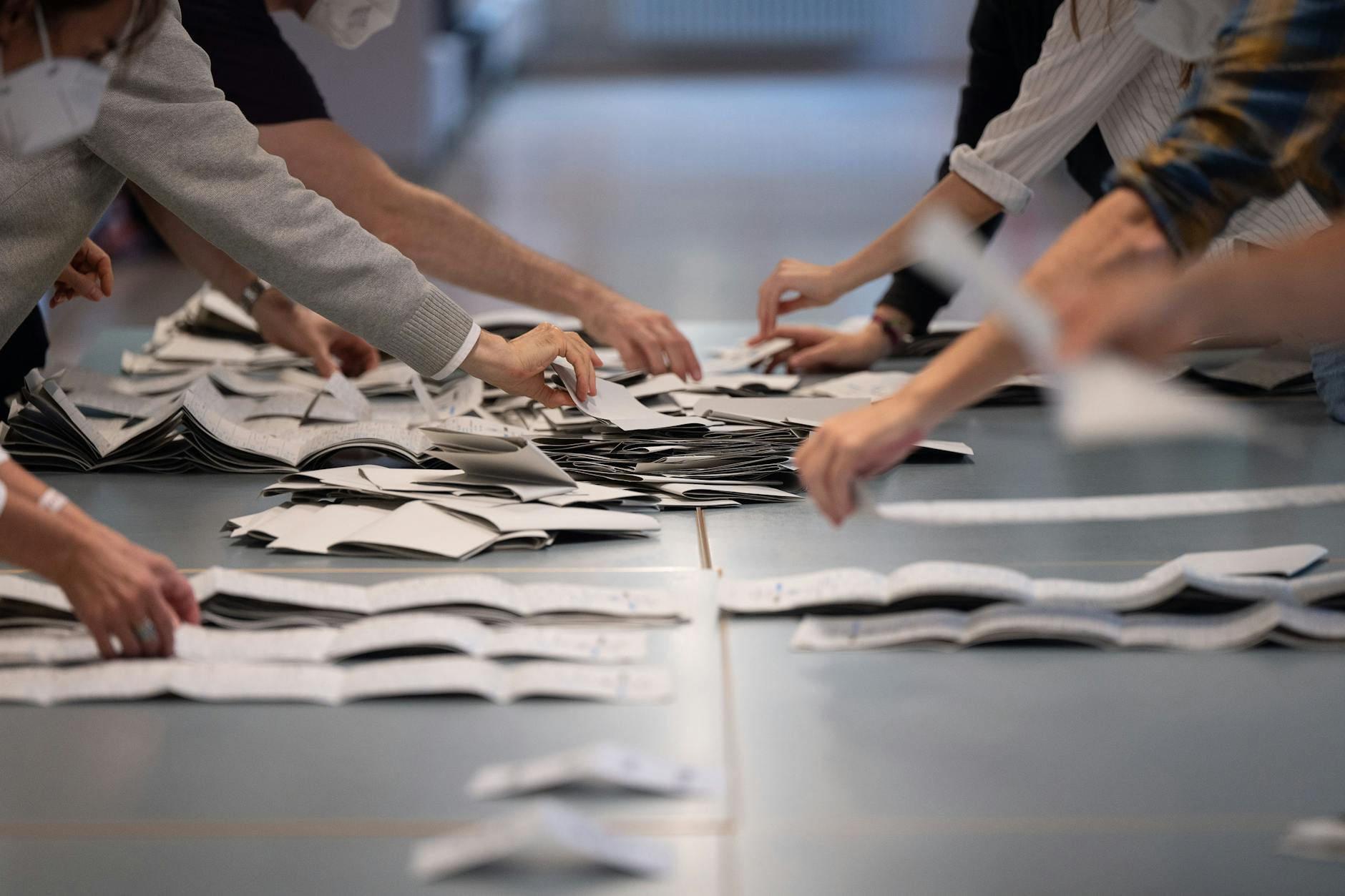 Wahlhelfer zählen in einem Wahllokal Stimmzettel für die Bundestagswahl.