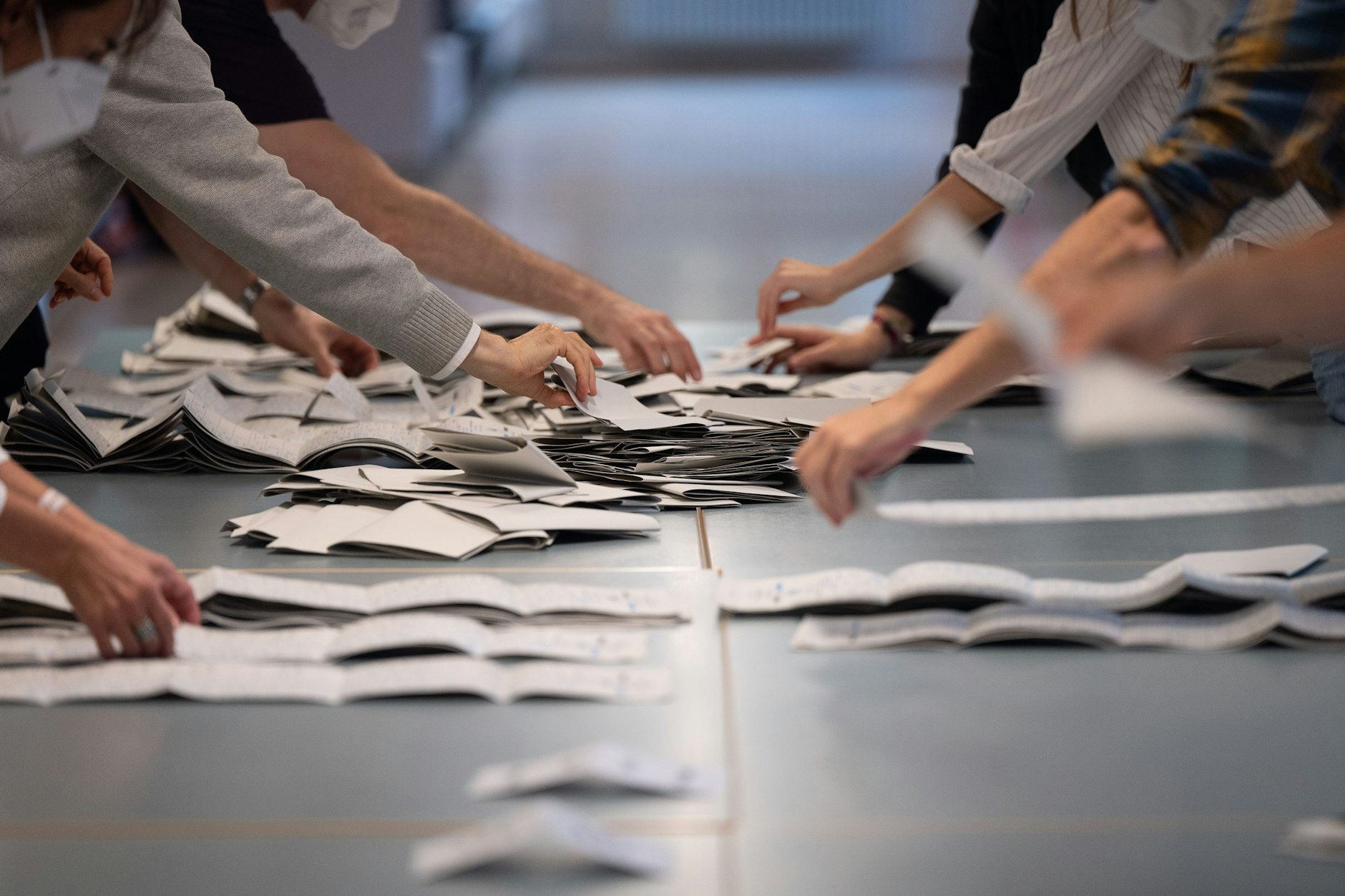 Wahlhelfer zählen in einem Wahllokal Stimmzettel für die Bundestagswahl.