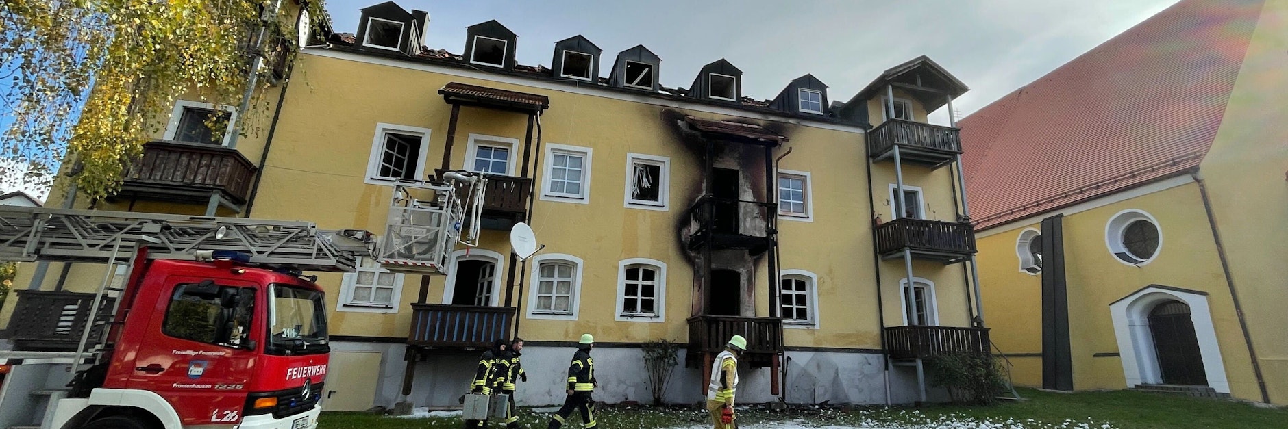 23.10.2021, Bayern, Reisbach: Feuerwehrleute stehen vor einem Haus in Reisbach im niederbayerischen Landkreis Dingolfing-Landau.. Drei Frauen und ein frühgeborenes Baby sind hier bei einem Brand ums Leben gekommen. Foto: Armin Weigel/dpa +++ dpa-Bildfunk +++