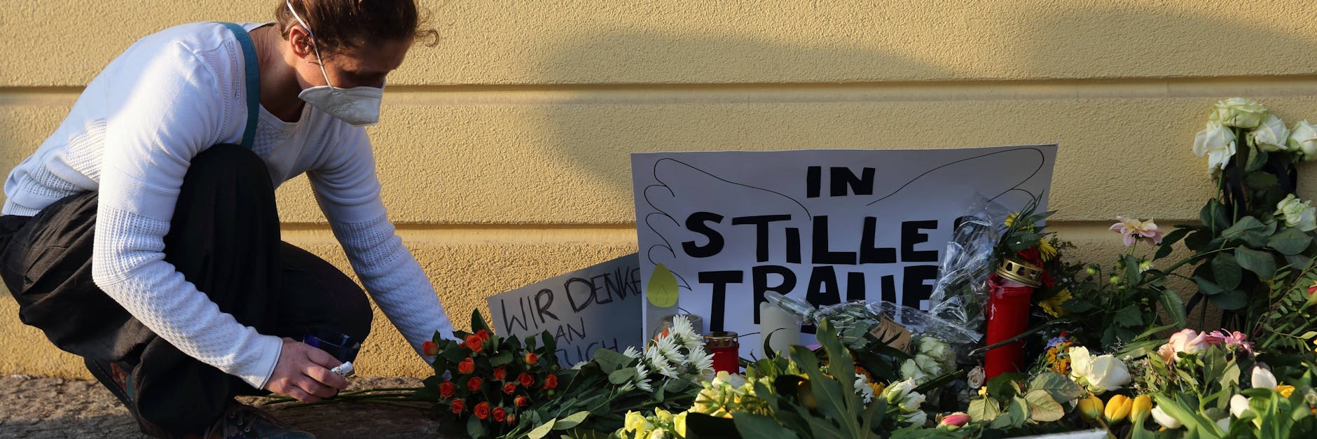 Eine Frau legt am Tag nach der Tat Blumen nieder und gedenkt der Opfer am Babelsberger Oberlinhaus.