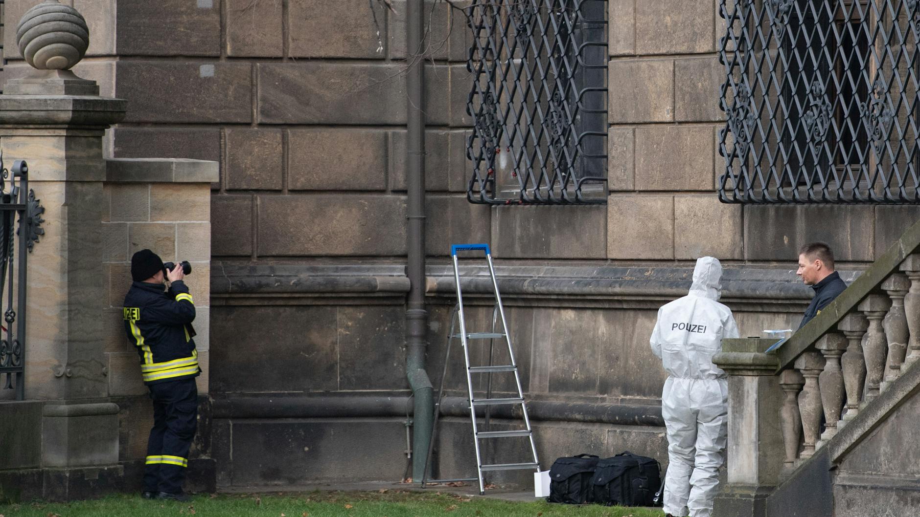 Beamte der Spurensicherung stehen neben dem Gitterfenster, aus deren unterem Rand (über der Leiter) ein Stück herausgeschnitten worden war. 