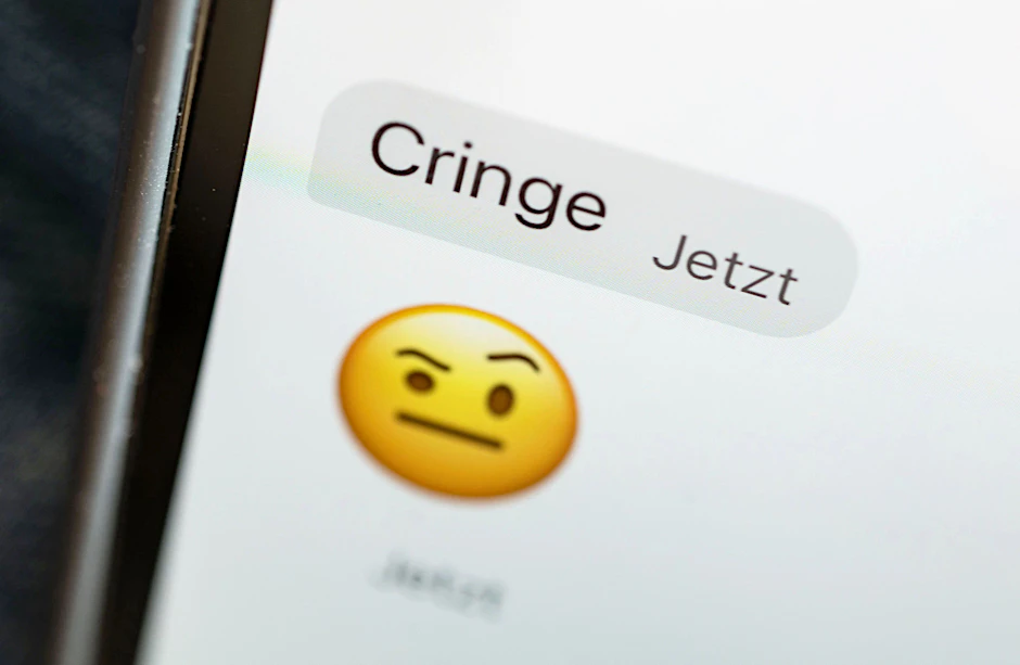 Das Wort „cringe“ ist auf dem Display eines Mobiltelefons zu sehen.