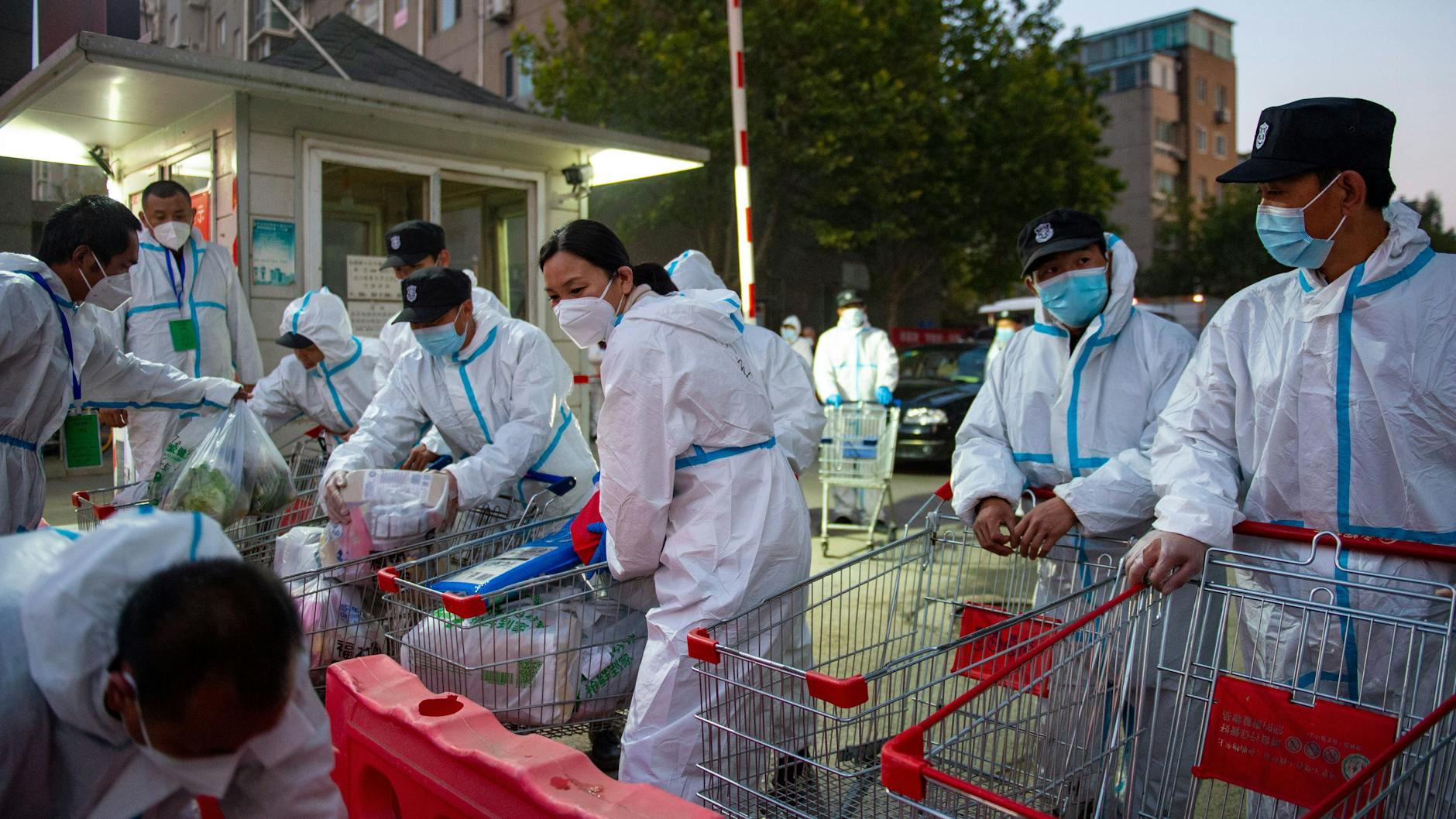 Mitarbeiter der Epidemieprävention und -kontrolle versorgen die Bewohner der Hongfuyuan-Wohnanlage mit Dingen des täglichen Bedarfs. Mehrere Wohnkomplexe wurden abgeriegelt.