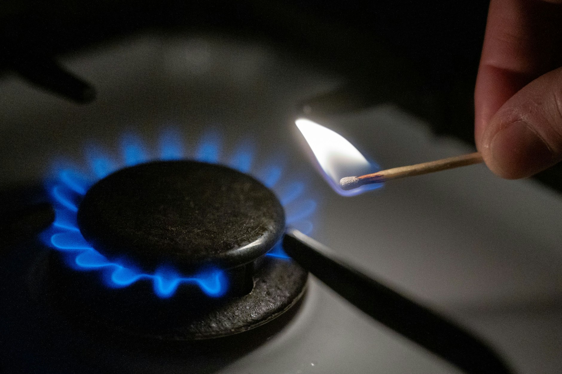 Kann teuer werden: Eine Gasflamme wird auf einem Küchenherd mit einem Streichholz entzündet (Symbolbild).&nbsp;