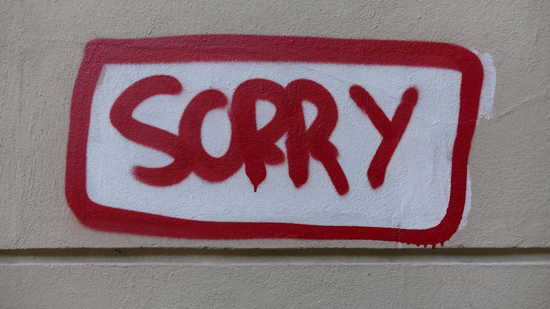 Auf einer Wand steht das Wort „Sorry“.