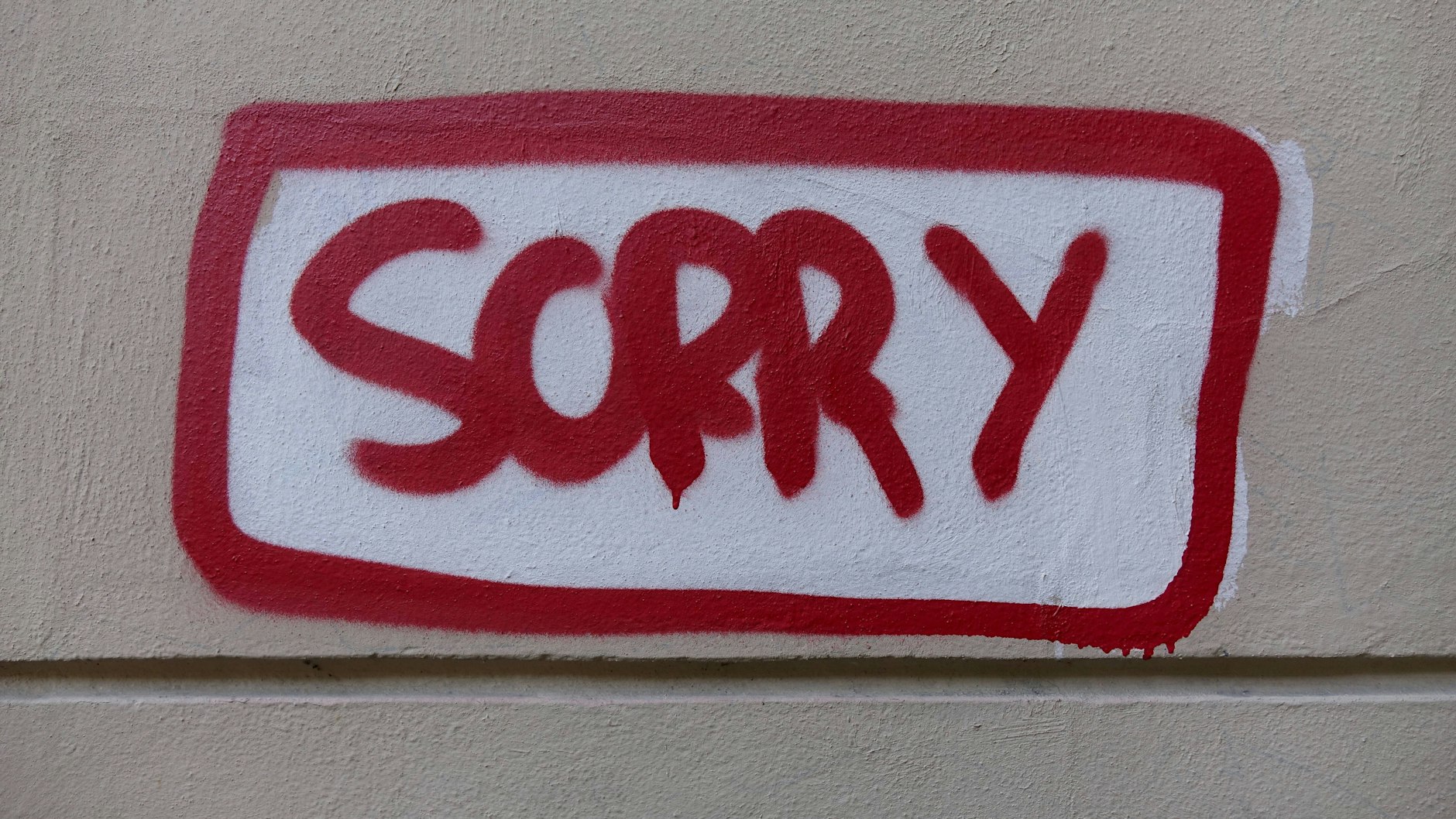 Auf einer Wand steht das Wort „Sorry“.
