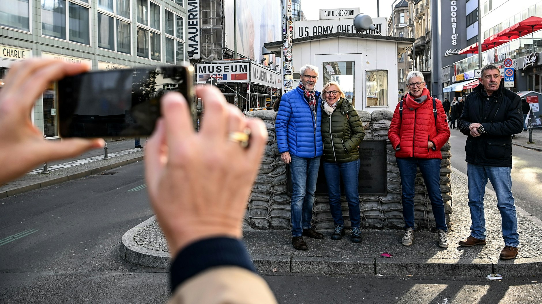 Die Ehepaare Margit und Bernhard Bus (r.) und Gabi und Josef Schmidt stehen am Checkpoint Charlie an der Kontrollbaracke für ein Selfie an. 