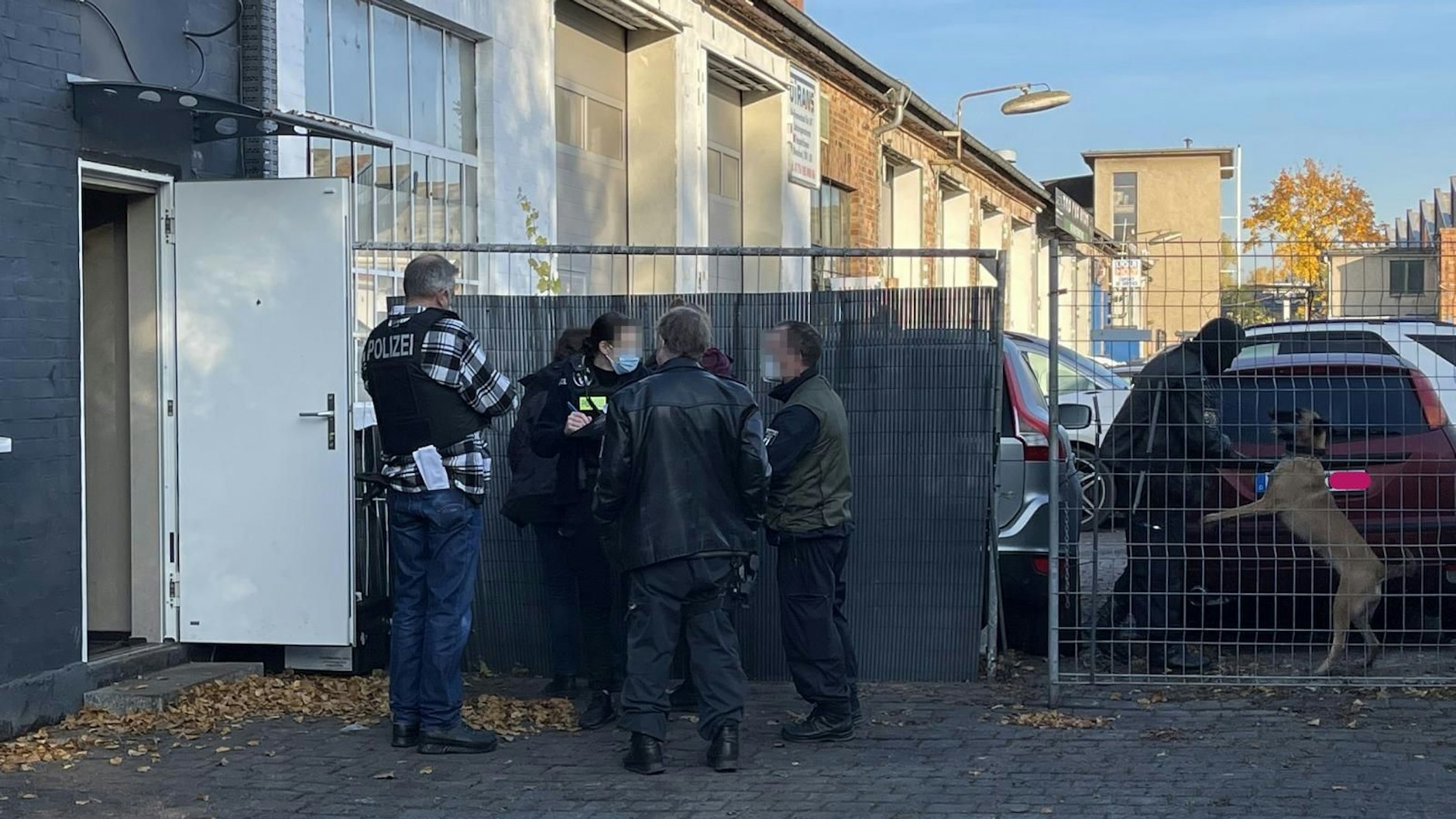Einsatzkräfte der Polizei Berlin stehen am Donnerstag auf einem Gewerbehof in der Liebermannstraße in Weißensee.