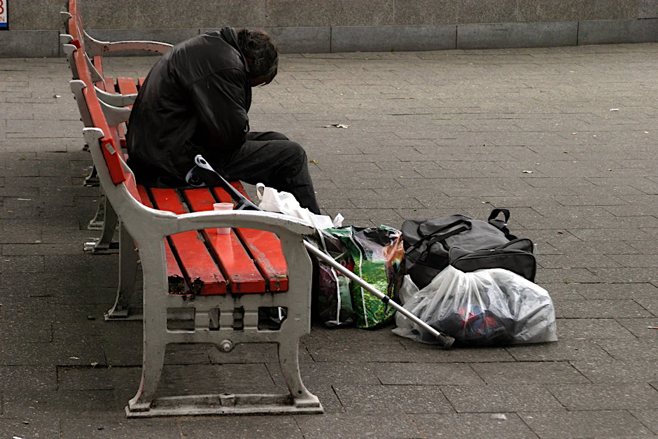 Ein Obdachloser sitzt in Berlin zusammengesunken auf einer Bank (Symbolbild).