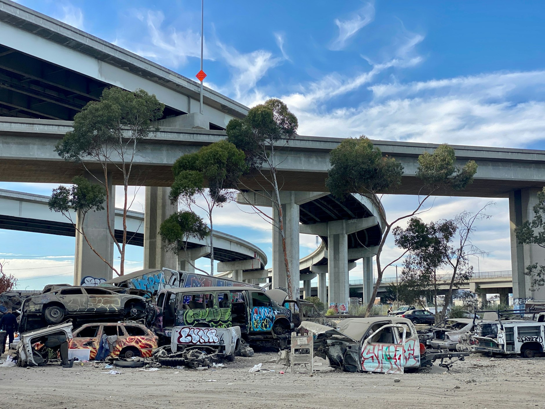 Die I-880 verzweigt sich in alle Himmelsrichtungen, darunter türmen sich Berge aus Schrott.