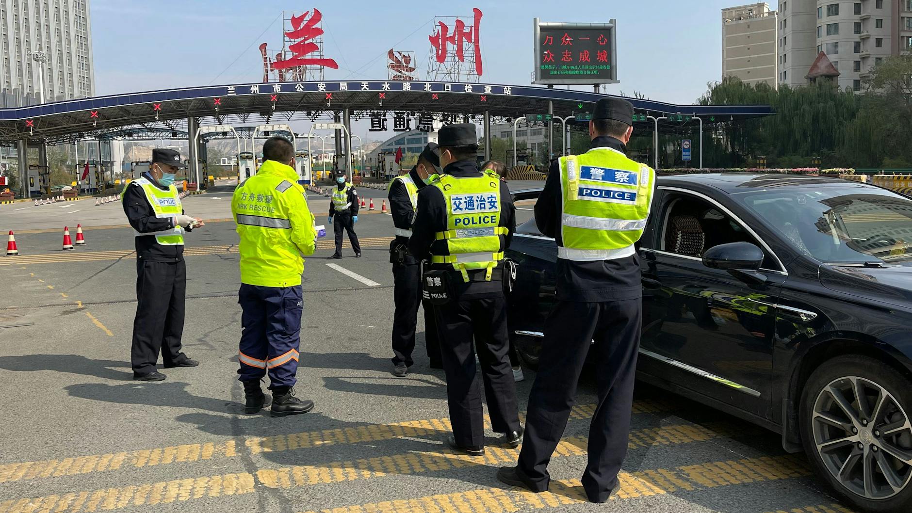Polizeibeamte kontrollieren Corona-Tests an einem Checkpoint in der chinesischen Stadt Lanzhou.