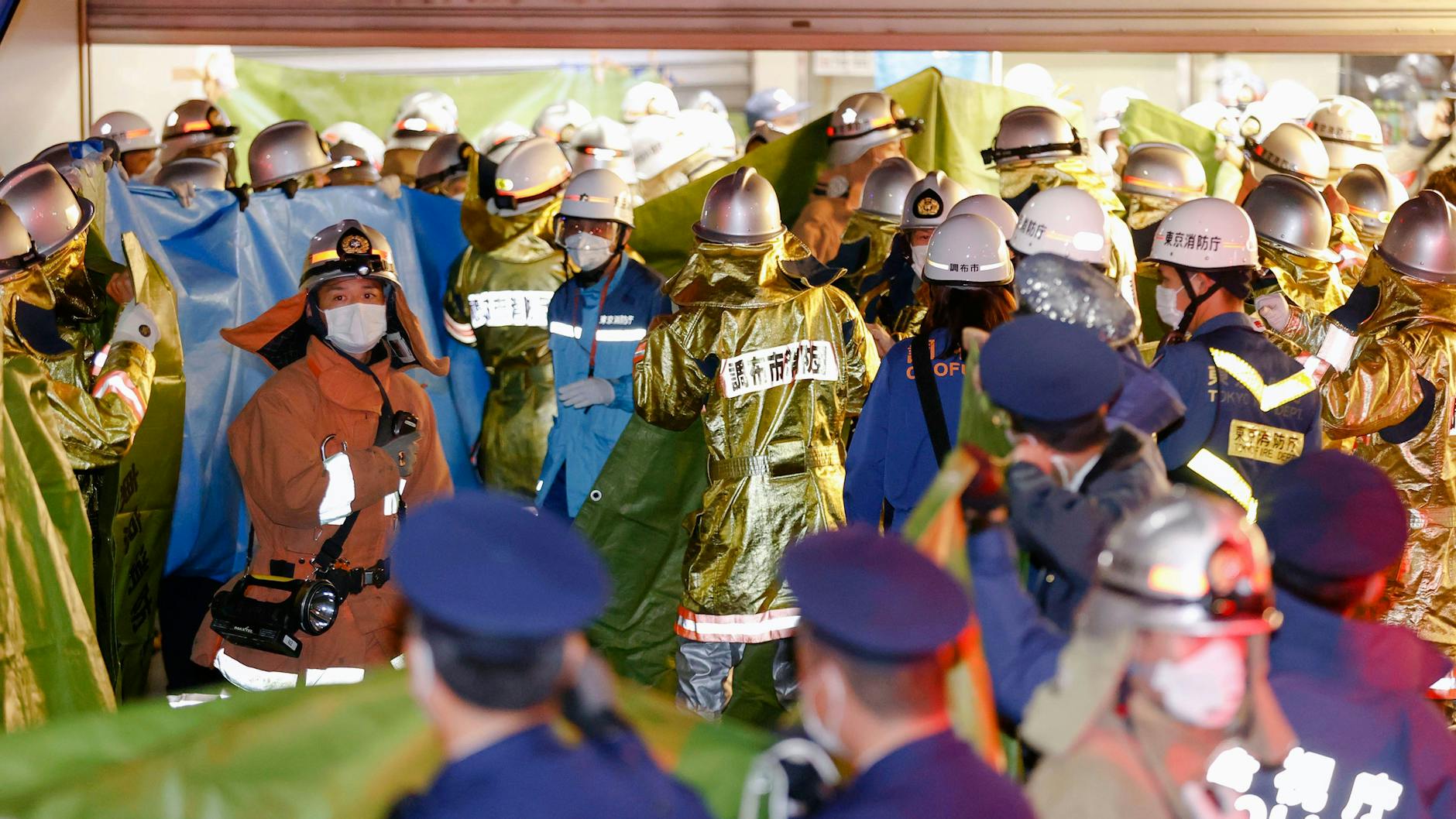 Feuerwehrleute versammeln sich am Bahnhof Kokuryo, nachdem in einem Zug der Keio-Linie ein Feuer ausgebrochen war. Die Polizei nahm den 24 Jahre alten Mann noch am Tatort fest, wie japanische Medien berichteten.