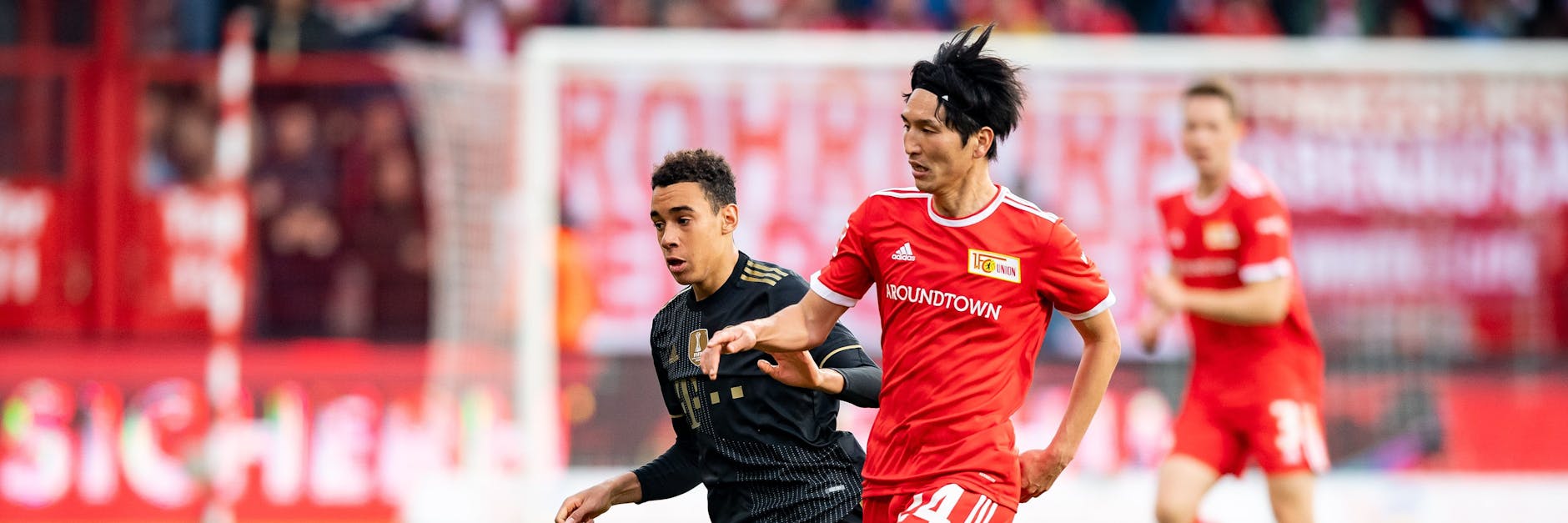 Unions Genki Haraguchi (r.) – hier im Duell mit Bayerns Jamal Musiala – kommt immer besser bei den Eisernen in Schwung. 