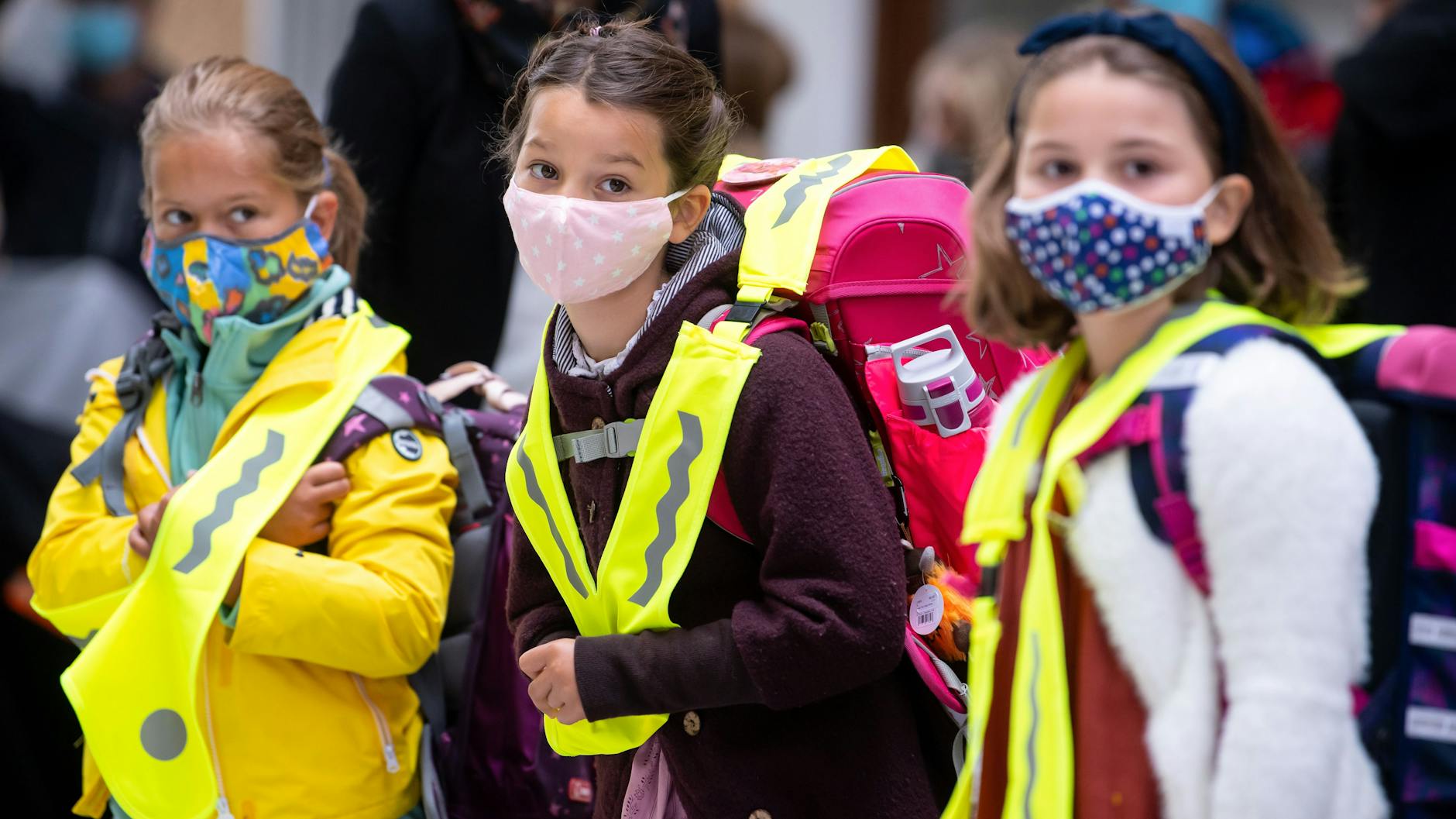 Schülerinnen einer Grundschule kommen mit Mund-Nasen-Schutz zum Unterricht. In Berlin gibt es für die Klassen eins bis sechs derzeit keine Maskenpflicht. 
