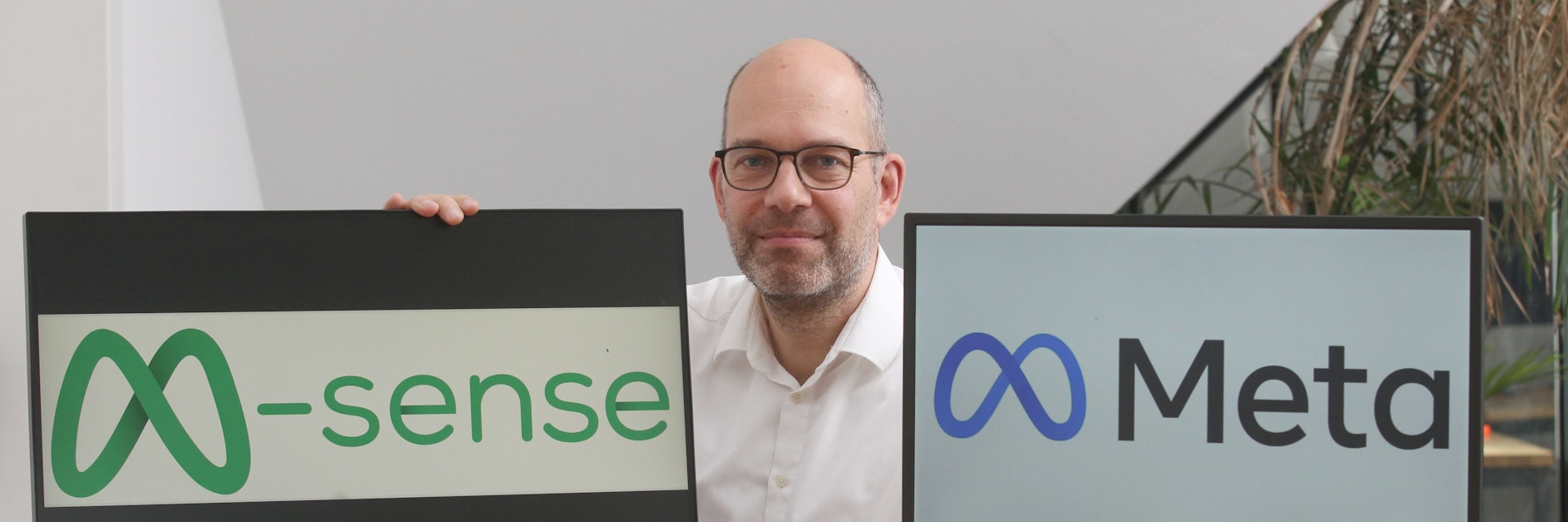 Newsenselab-Chef Markus Dahlem mit den beiden M-Markenzeichen, die sich verblüffend ähnlich sehen: Das linke entwickelte 2020 das Kreuzberger Unternehmen für ihre Medizin-App, das rechte ist das neue Facebook-Logo.