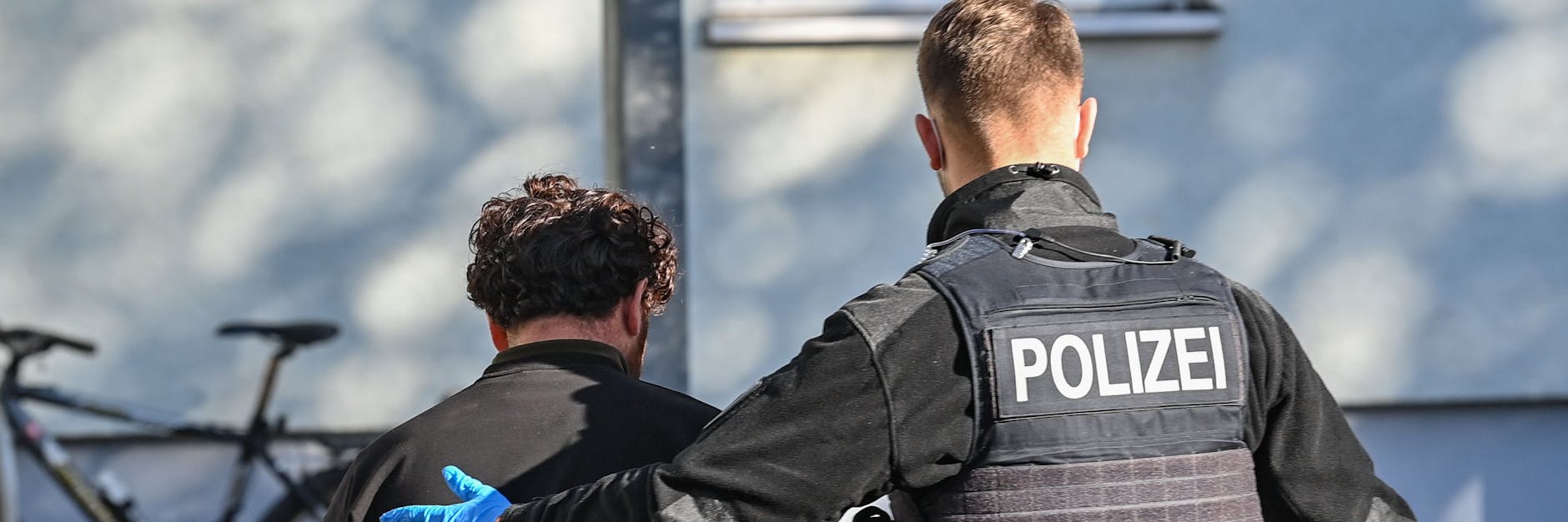 Ein Beamter der Bundespolizei bringt einen Migranten, der zuvor im Stadtzentrum von Frankfurt (Oder) nahe der deutsch-polnischen Grenze aufgegriffen wurde, zur ärztlichen Untersuchung.