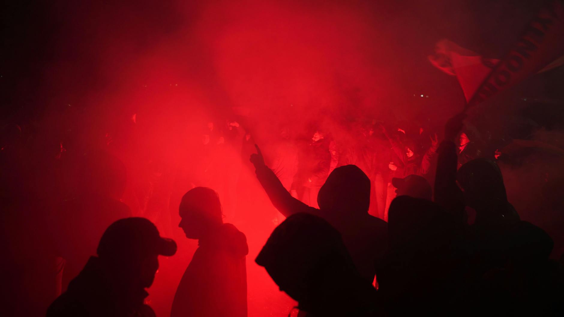 Fans des Fußballvereins Feyenoord Rotterdam entzünden Bengalos auf dem Weg zum Olympiastadion.