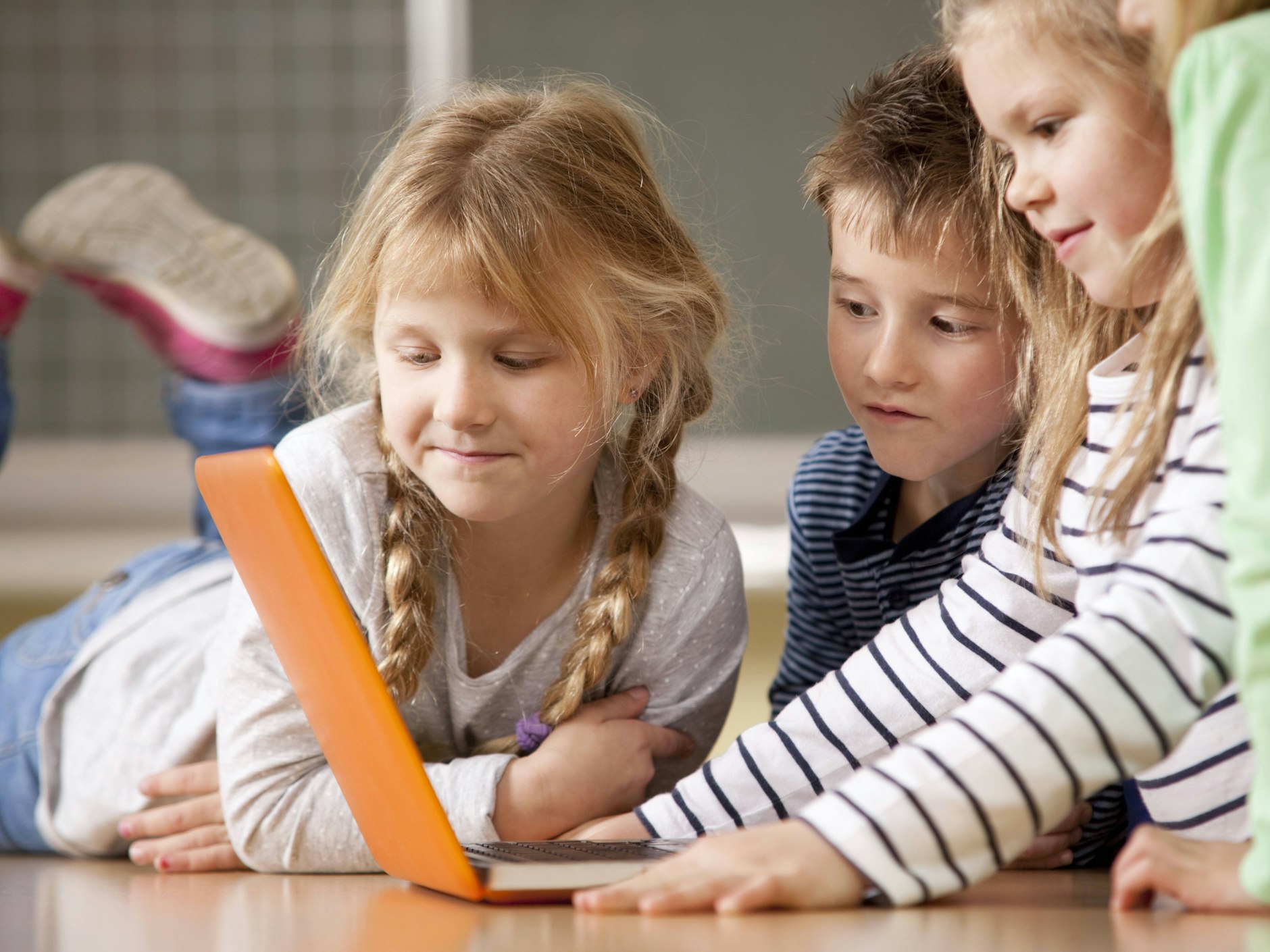 Grundschüler, die im Unterricht einen Laptop nutzen.