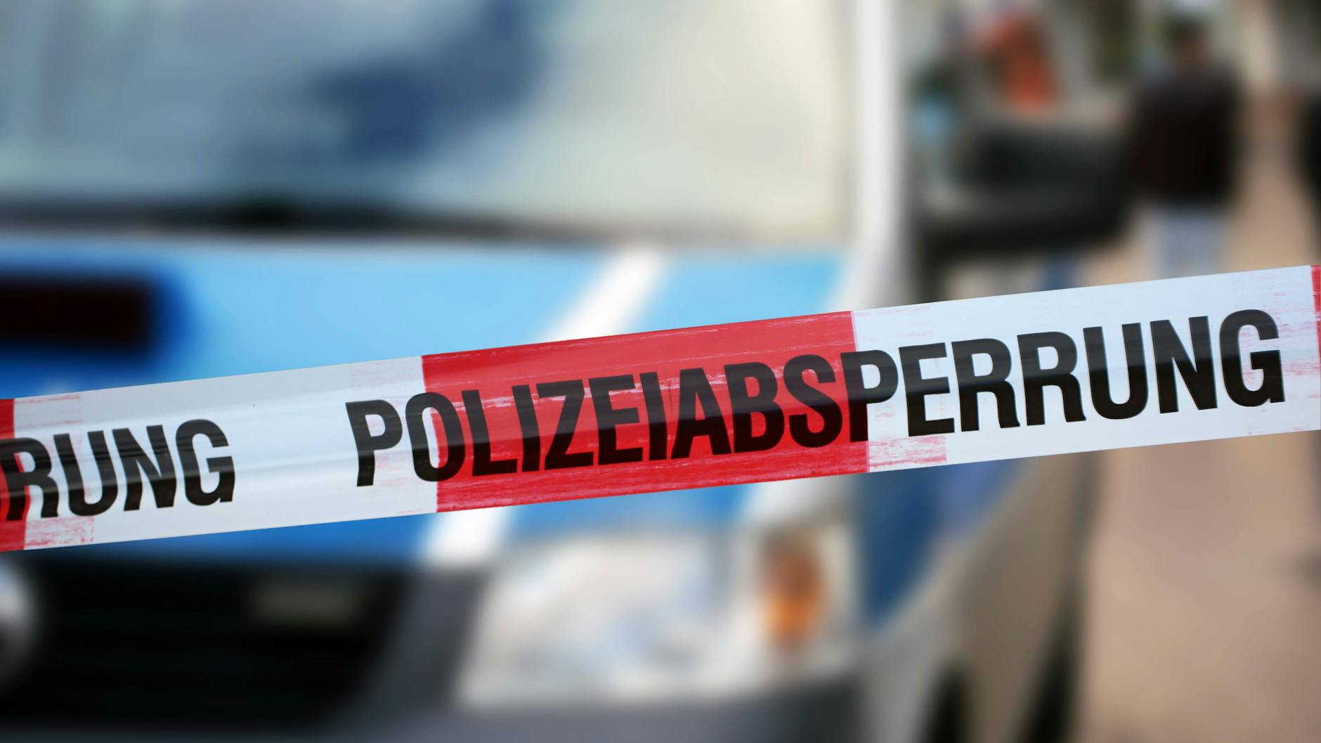 Polizisten haben einen Tatort vor einem Gebäude abgesperrt (Symbolbild). 