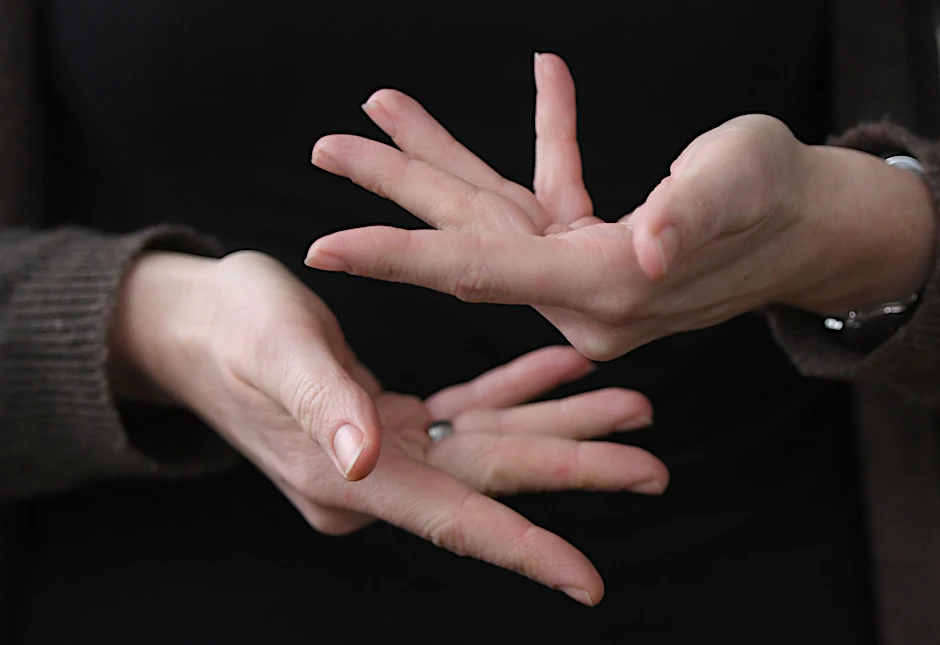 Eine Gebärdendolmetscherin zeigt mit ihren Fingern das Wort «beraten» in Gebärdensprache.&nbsp;&nbsp;