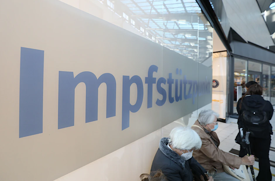 Menschen warten an einem Impfstützpunkt auf ihre Impfung.
