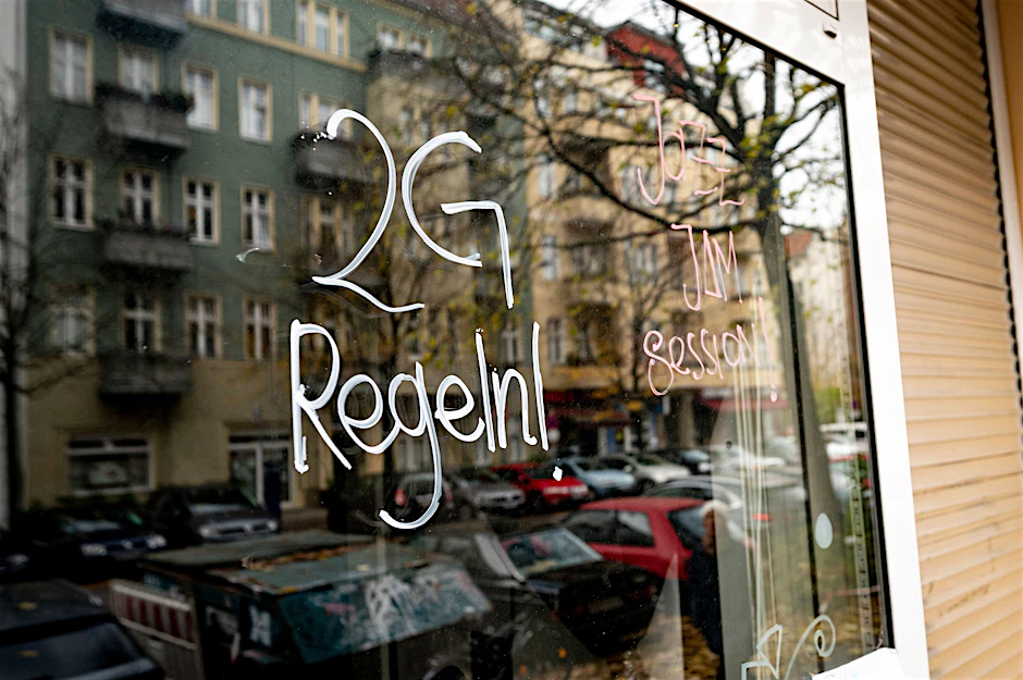An einer Kneipe in Berlin Prenzlauer-Berg steht ein Hinweis auf 2G-Regeln. Bald könnte das überall in Berlin gelten - außer in Supermärkten und Drogerien.&nbsp;&nbsp;