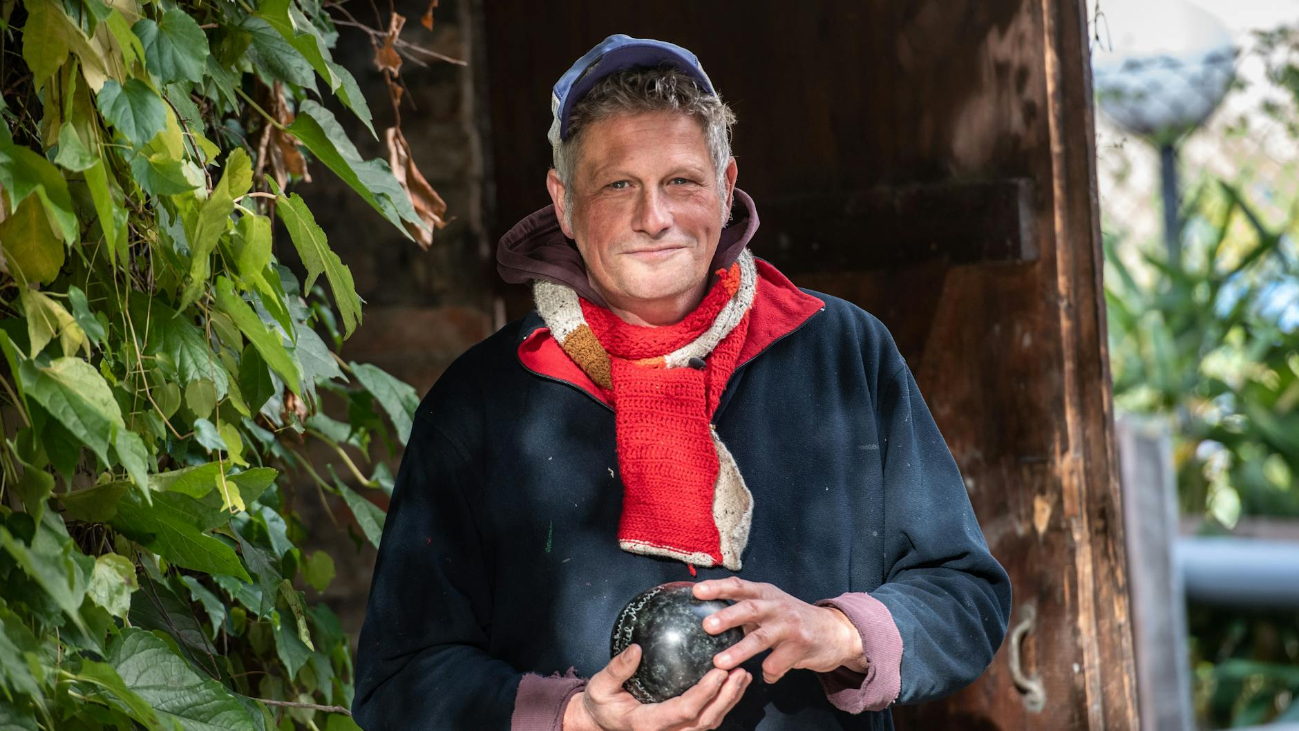 Bildhauer Todosch Schlopsnies (55) steht auf dem St. Jacobi Friedhof in Neukölln und hält eine steinerne Kugel in den Händen, die aus einem ehemaligen Grabstein entstanden ist.