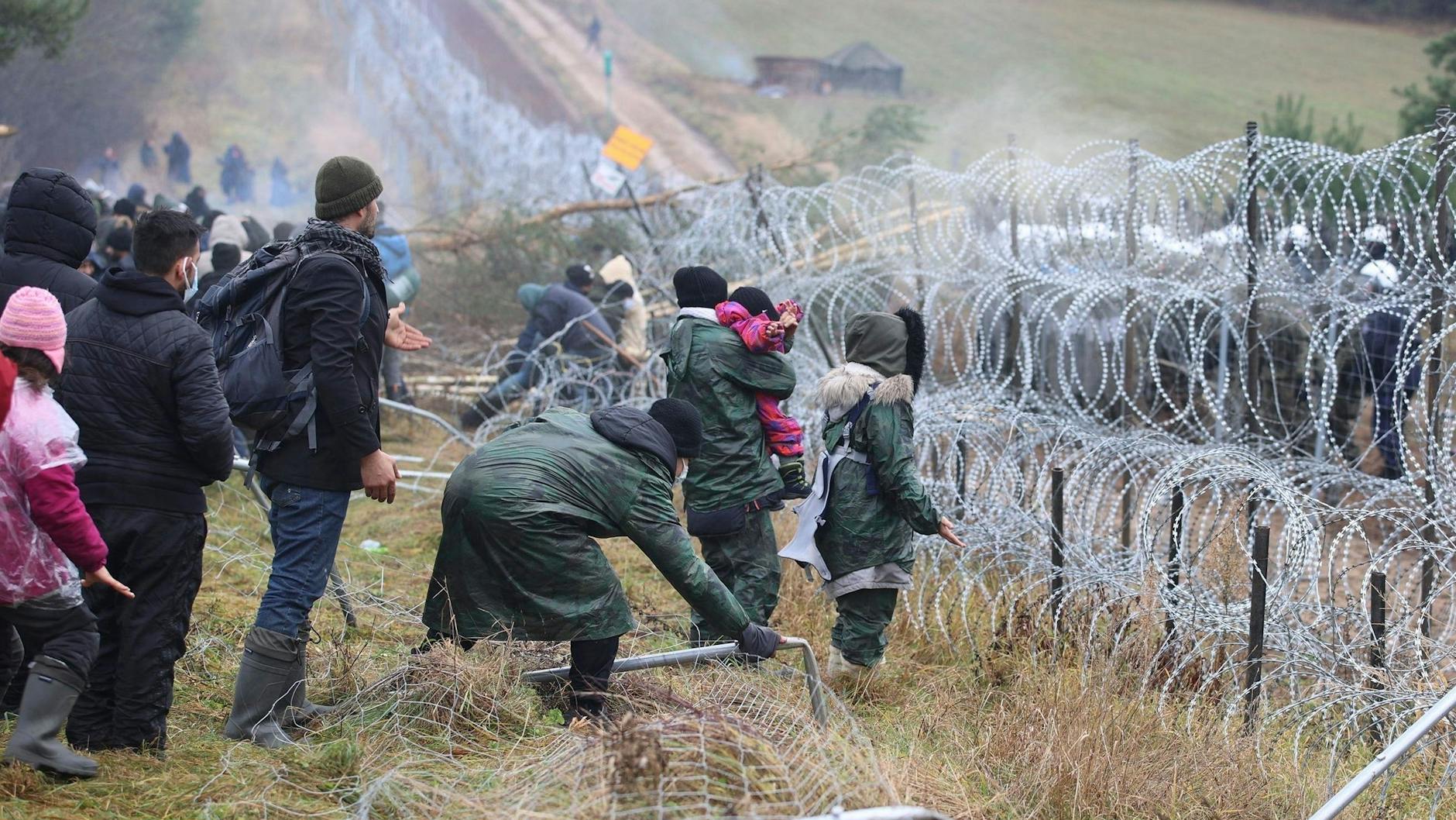 Migranten stehen an der schwer gesicherten polnischen Grenze zu Belarus.