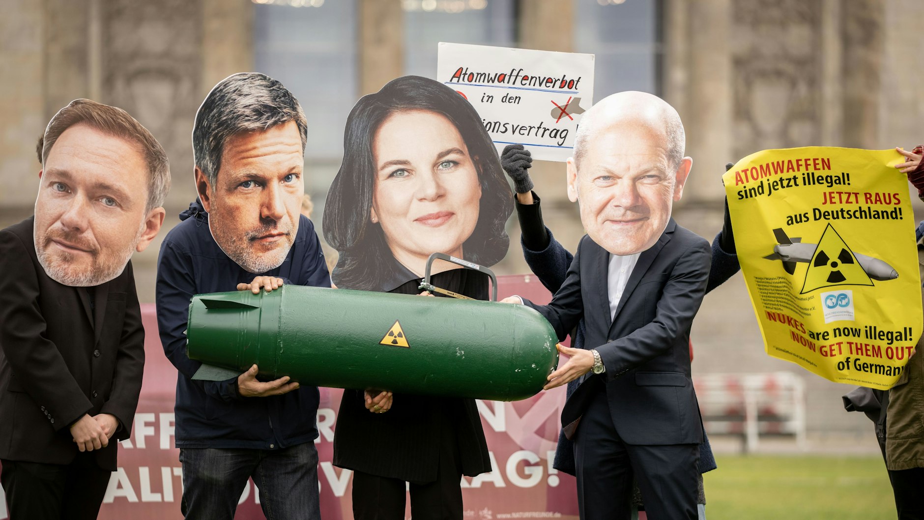 Mitglieder von Friedensorganisationen demonstrieren mit den Konterfeis von Christian Lindner, FDP, Robert Habeck und Annalena Baerbock, Bündnis 90/Die Grünen, und Olaf Scholz, SPD (v.l.), vor dem Reichstagsgebäude für ein UN-Atomwaffenverbot im Koalitionsvertrag. 