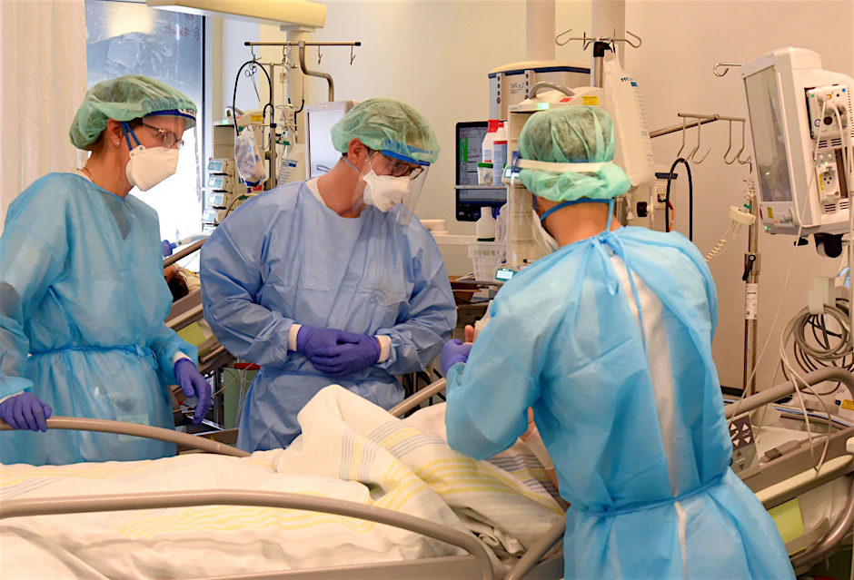 Klinik-Mitarbeiter am Bett eines schwerkranken Patienten auf einer Covid-Station.&nbsp;
