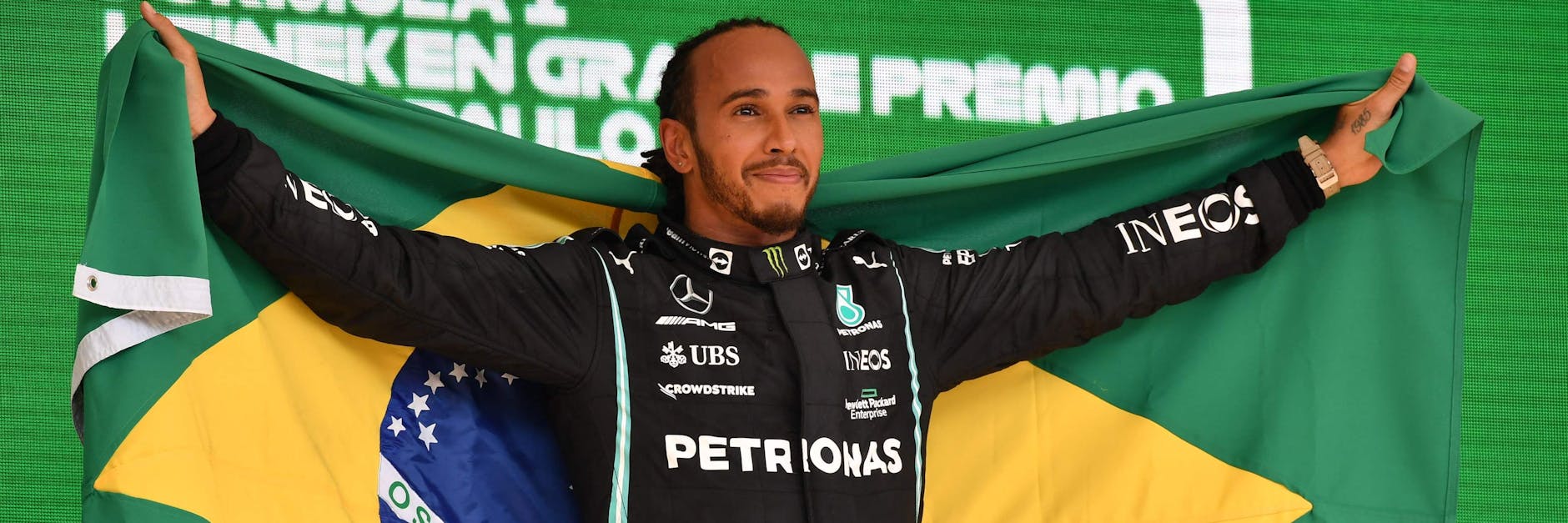 Der PS-König von Brasilien mit Fahne: Lewis Hamilton hat nach seiner irren Aufholjagd allen Grund, auf dem Siegerpodest stolz zu lächeln. 