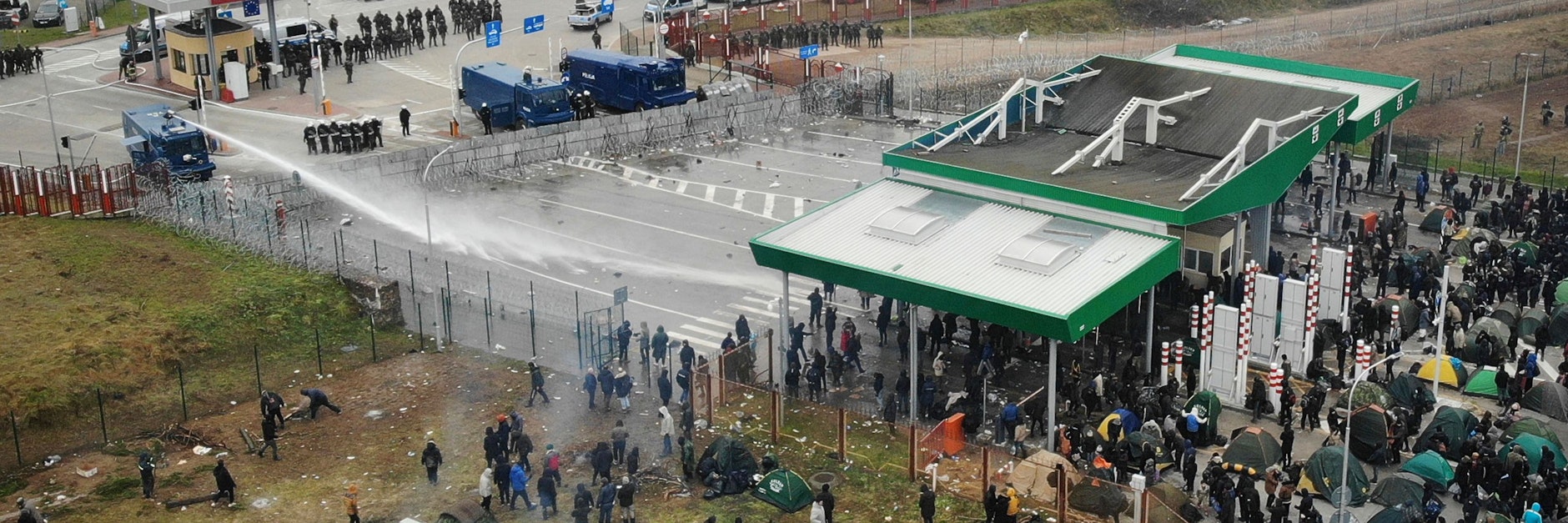 Am Grenzübergang Kuznica sind polnische Wasserwerfer im Einsatz. Menschenmengen stehen auf belarussischer Seite.