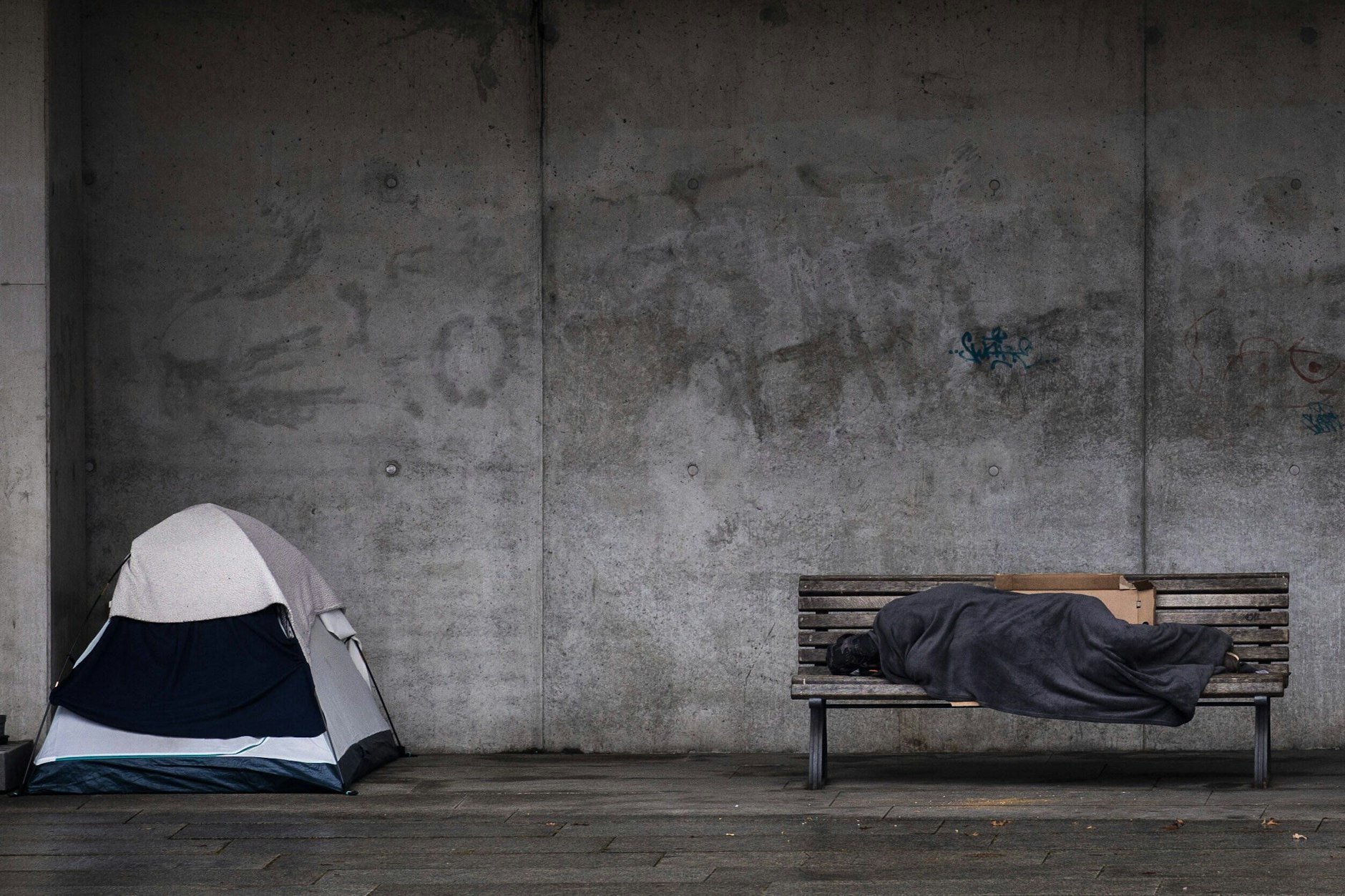 Ein Obdachloser schläft auf einer Bank in Berlin.