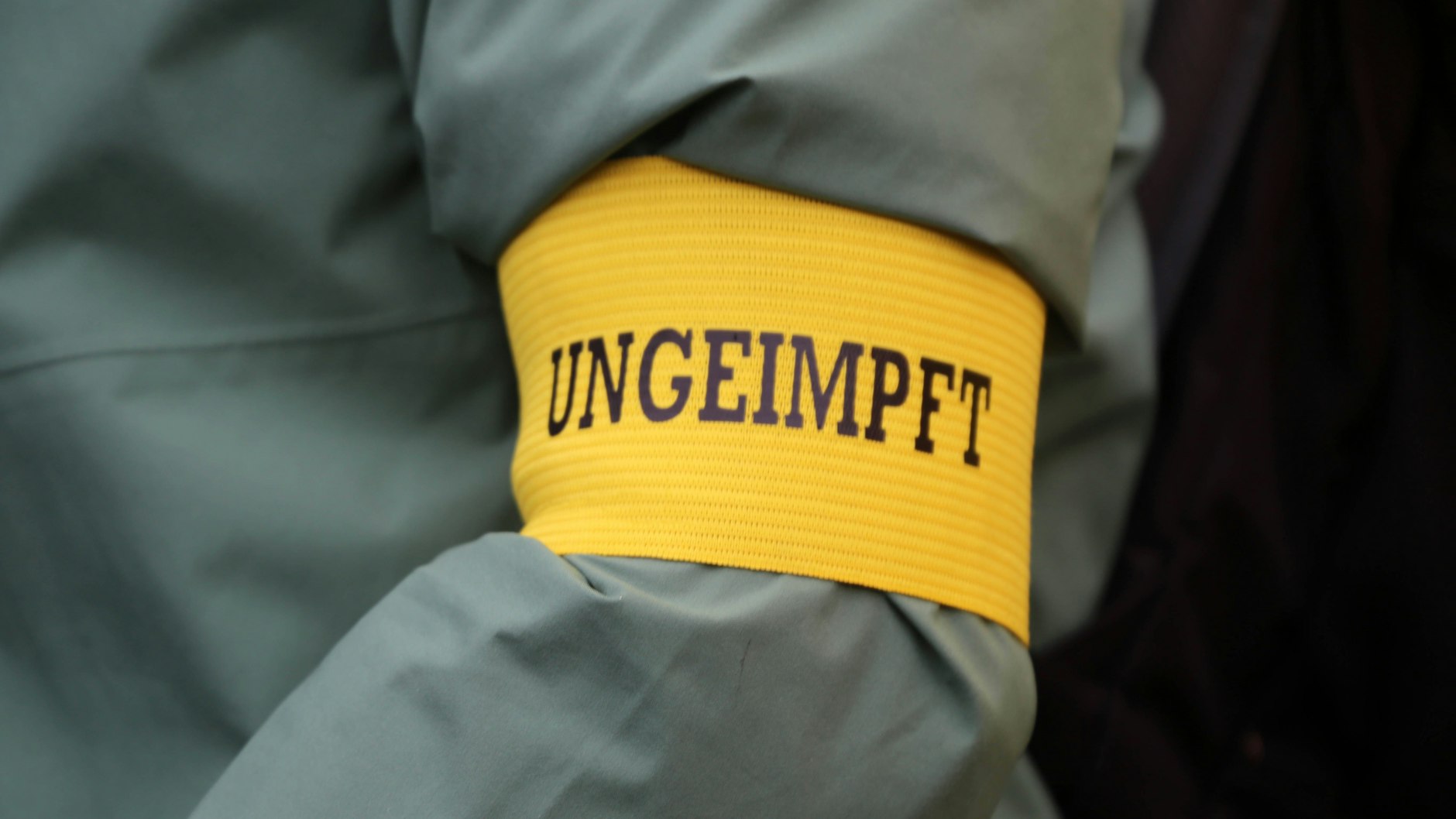 Ein Demonstrant trägt als Zeichen des Protests gegen Corona-Beschränkungen für Ungeimpfte eine Armbinde mit der Aufschrift „Ungeimpft“ (Symbolbild). Juristen befassen sich aktuell mit der Frage: Welche Corona-Regeln würden zu weit gehen?