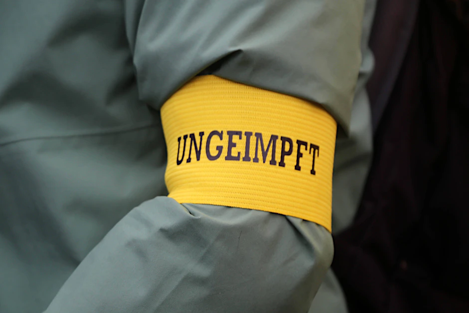 Ein Demonstrant trägt als Zeichen des Protests gegen Corona-Beschränkungen für Ungeimpfte eine Armbinde mit der Aufschrift „Ungeimpft“ (Symbolbild). Juristen befassen sich aktuell mit der Frage: Welche Corona-Regeln würden zu weit gehen?