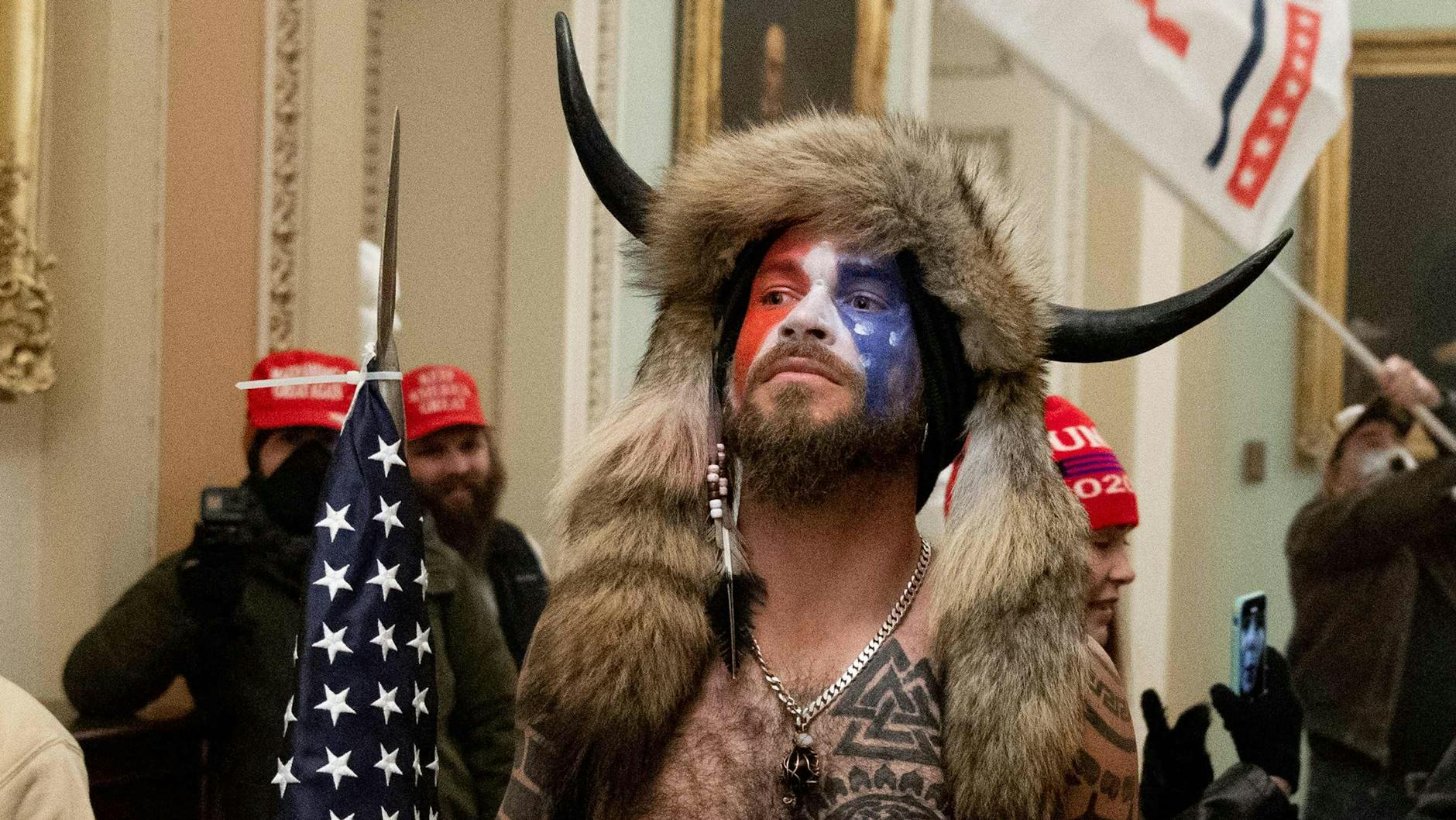 Bilder von Jacob Chansley mit nacktem Oberkörper voller Tätowierungen, bemaltem Gesicht, einer Fellmütze mit Büffelhörnern und einem Speer mit US-Flagge gingen um die Welt (Archivbild).
