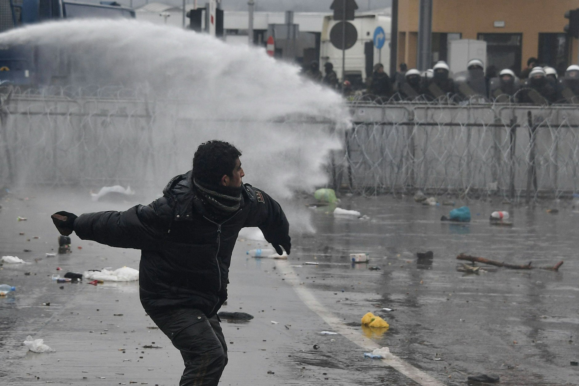 Ein Migrant wirft ein Stein in Richtung polnische Grenzsoldaten.&nbsp;