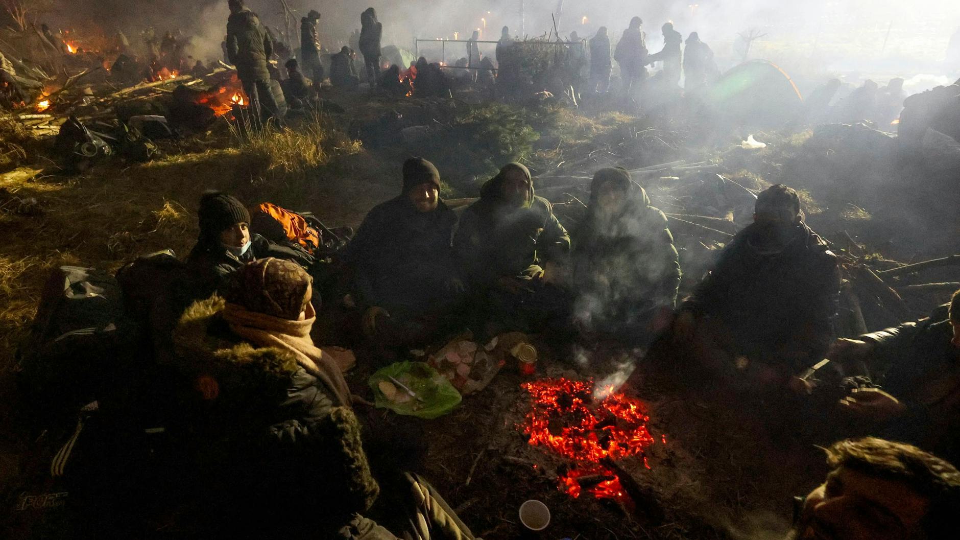 Belarus: Migranten wärmen sich am Lagerfeuer. 