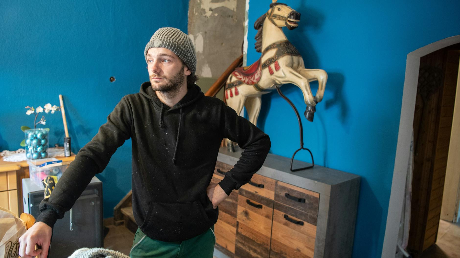 Tim Himmes steht im bereits teilweise renovierten Wohnzimmer seines Hauses in Insul. Sein altes hölzernes Karusellpferd auf der Kommode hatte der 21-jährige Schausteller im Juli aus den Fluten retten können. 