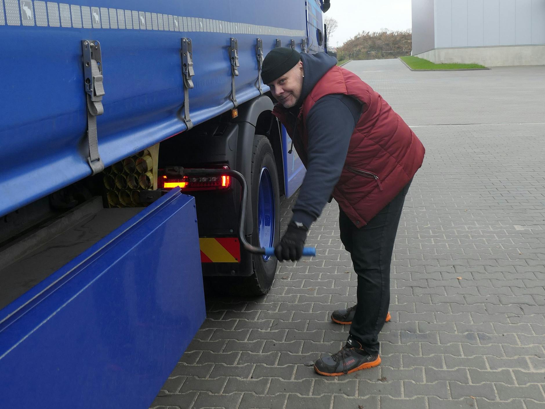 Kai Schulze kurbelt die Stütze eines Lkw-Aufliegers hoch, nachdem er ihn an die Zugmaschine gekoppelt hat.