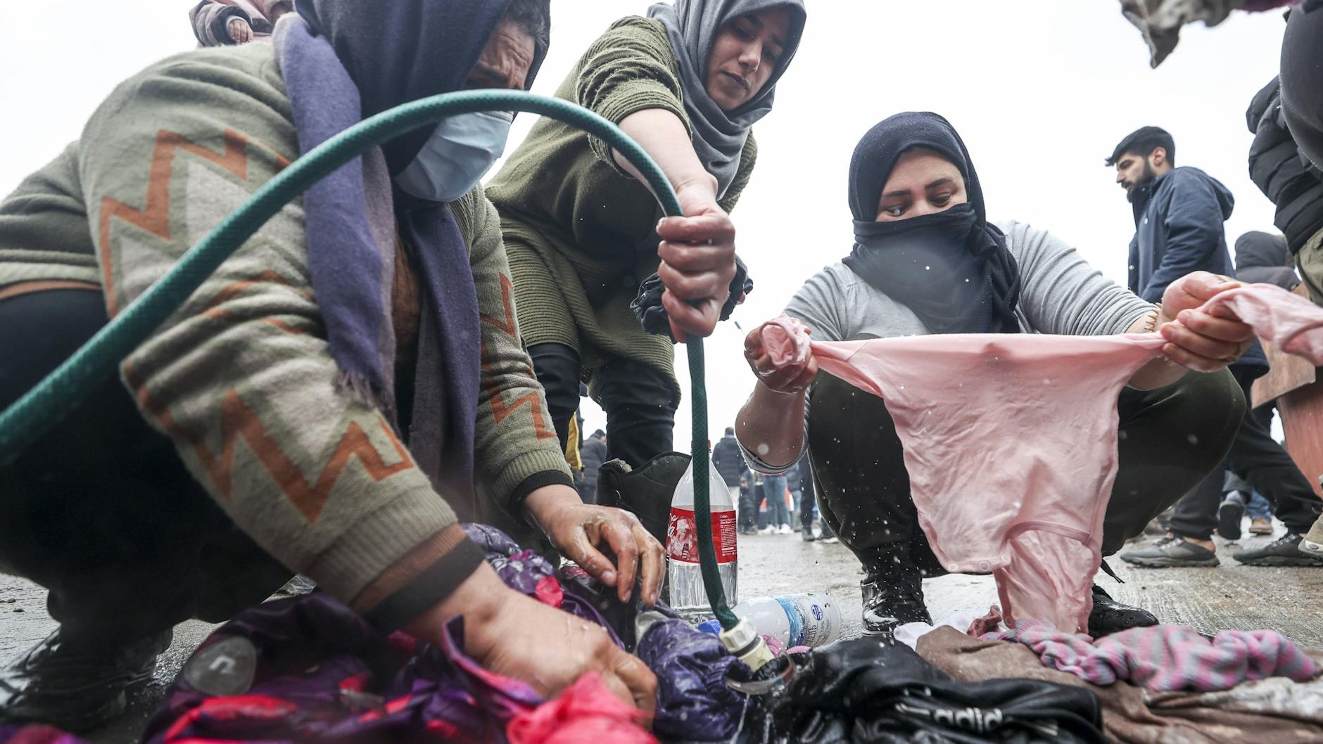 Flüchtlingsfrauen an der belarussisch-polnischen Grenze waschen Wäsche.