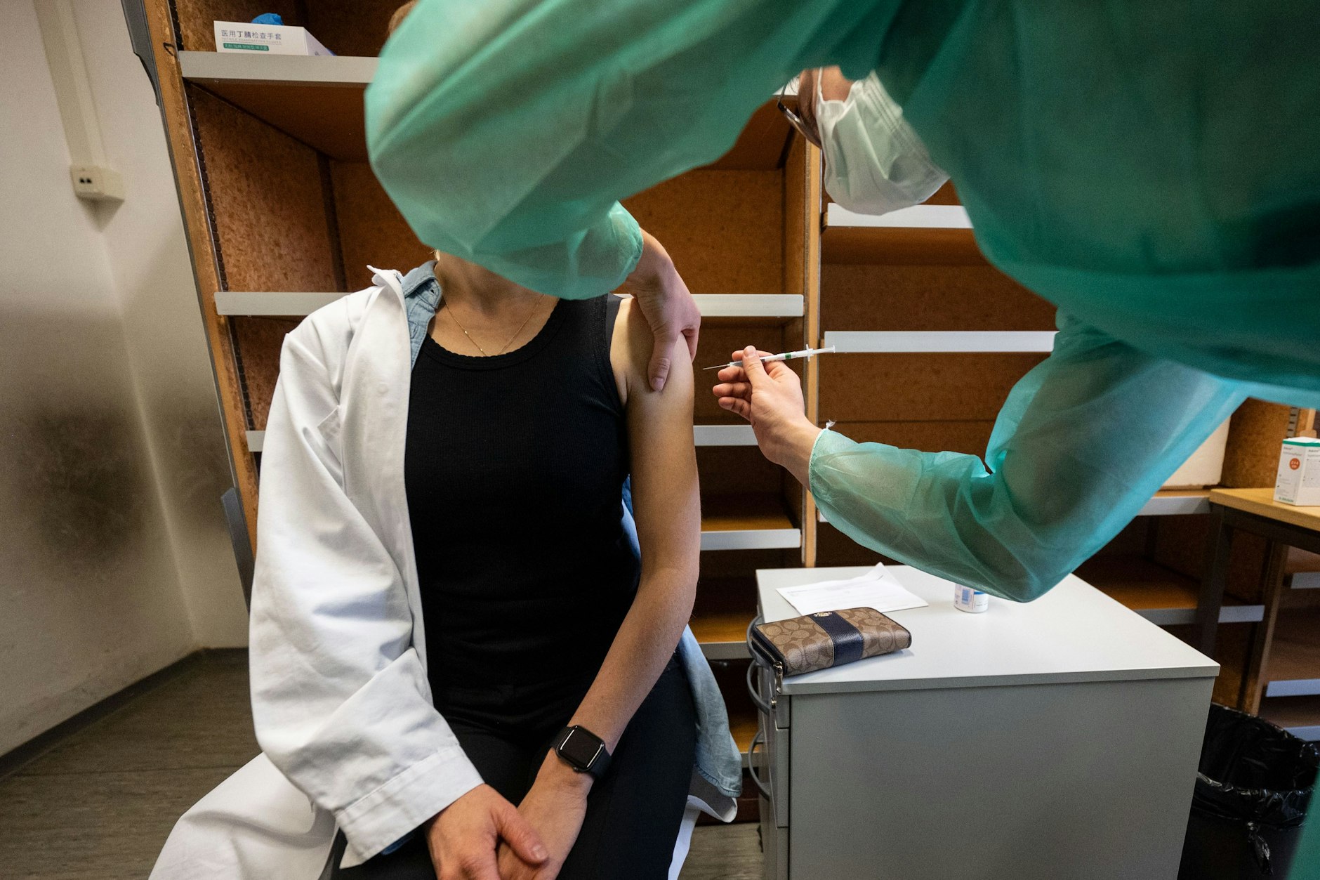 Eine Ärztin bekommt in eine Impfung von einem Medizinstudenten verabreicht.&nbsp;