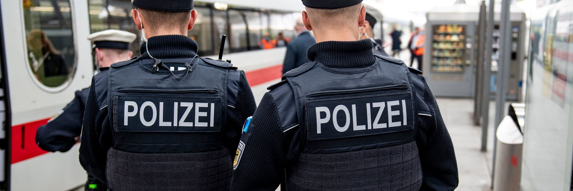  Bundespolizisten stehen vor der Abfahrt eines ICE an einem Gleis im Kieler Hauptbahnhof. In den Zügen der Deutschen Bahn wird die Mund-Nase-Bedeckungspflicht sowie die 3G-Regel kontrolliert.
